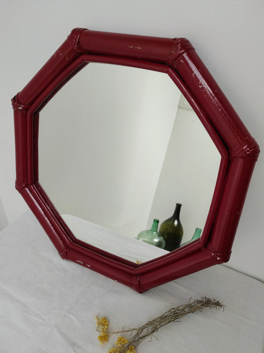 Miroir vintage octogonal en bois rouge style rotin. Miroir vintage octogonal de couleur rouge style bambou rotin à suspendre ou à poser.