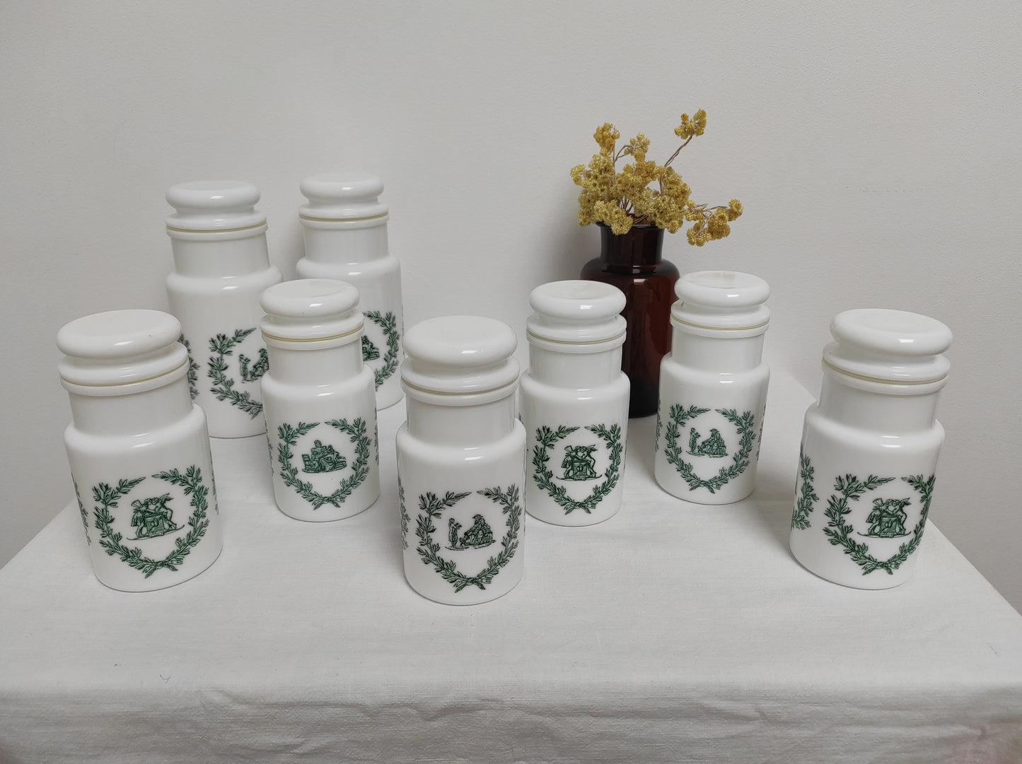 Pot d'apothicaire en opaline blanche. Bocal en verre ou ancien pot d'apothicaire en opaline blanche avec des décorations vertes. Ils sont dotés d'un bouchon hermétique et 3 motifs différents sur chaque pot. Made in Italy, Tous en très bon état.