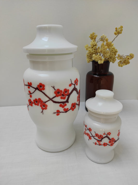 Anciens pots publicitaires en verre opaline blanc ARIEL.Ce lot de 2 pots publicitaires ARIEL style pots d'apothicaire en opaline blanc et aux motifs de fleurs de cerisier trouvera facilement sa place dans votre intérieur. Vous pourrez les utiliser en cuisine grâce à leurs bouchons hermétiques. Made in Belgium. Vintage