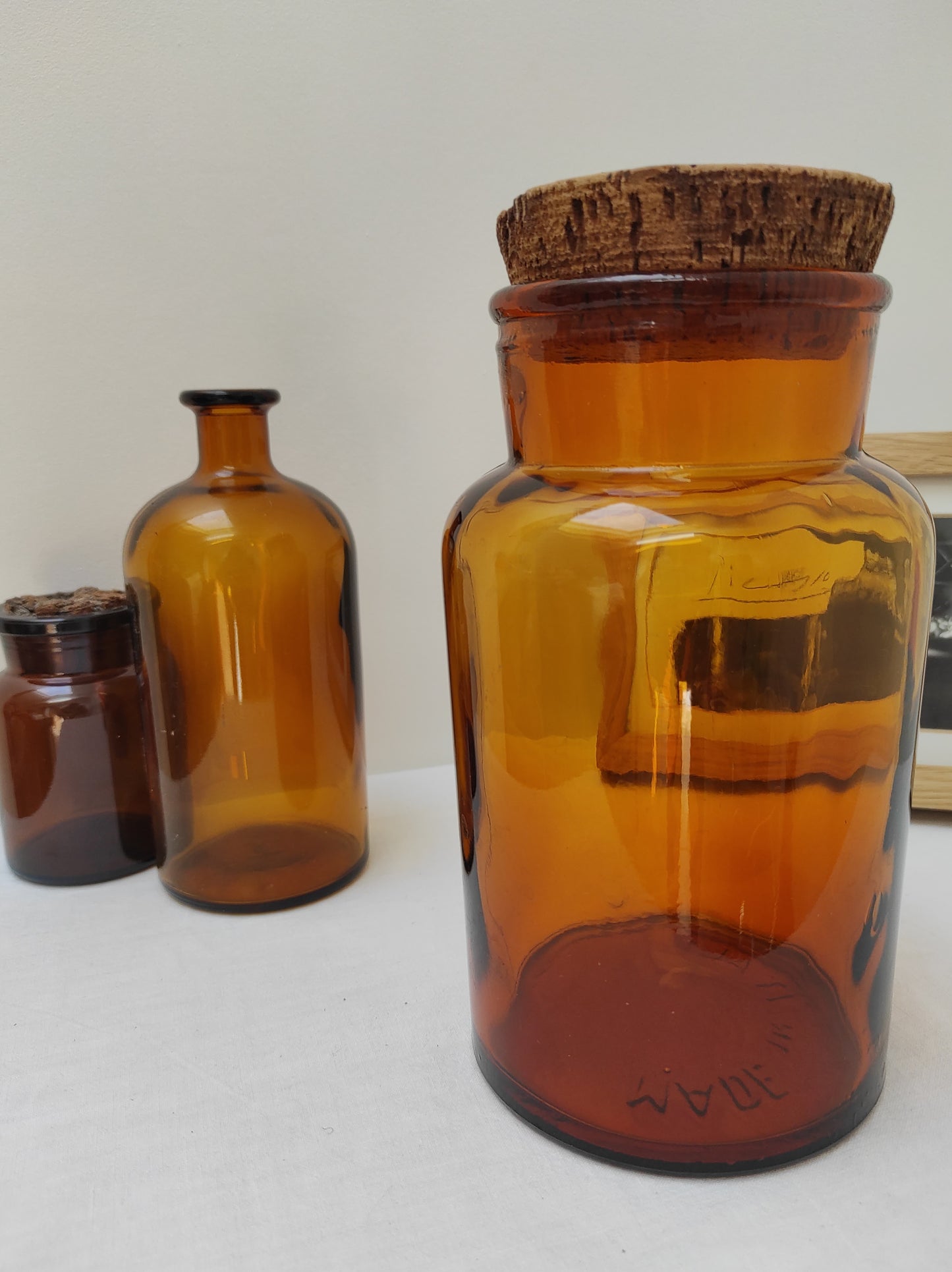 Pot à pharmacie ambré vintage. Ancien pot / bocal à pharmacie en verre ambré et son bouchon en liège. Made in Italy. En déco, il saura faire son effet en accumulation avec d’autres formats ou d'autres couleurs. En très bon état, quelques traces du temps sur le bouchon en liège (voir photo).