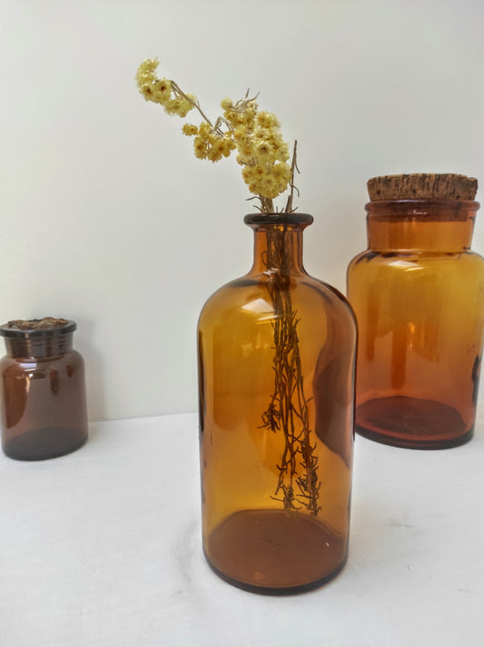 Flacon à pharmacie ambré vintage. Ancien flacon à pharmacie en verre ambré. En déco, il saura faire son effet en accumulation avec d’autres formats ou d'autres couleurs. En très bon état, malheureusement il a perdu son bouchon avec le temps.