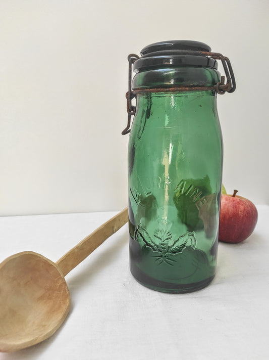 Ancien bocal en verre vert LA LORRAINE. Ce bocal vintage en verre vert estampillé en relief LA LORRAINE et d'un chardon, sera votre allié pour une maison zéro déchet pour stocker pâtes, riz, épices en cuisine, coton dans la salle de bain. En déco, il saura aussi faire son effet en accumulation avec d’autres formats ou couleurs. A noter : un petit éclat (voir photo), des traces de rouille sur le cerclage mais complètement fonctionnelle (c'est ce qui fait aussi son charme !) Contenance : 1 Litre