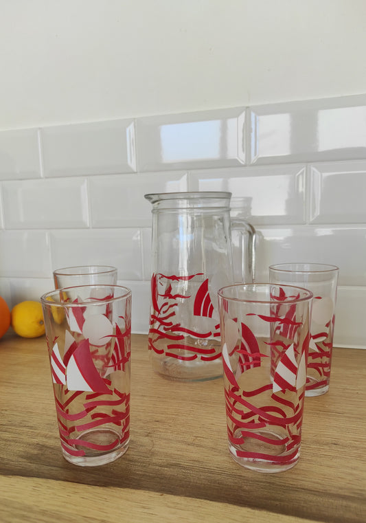 Service à orangeade Covetro vintage 5 pièces. Comme un air de vacances….avec ces motifs de voiliers et oiseaux rouges et blancs qui vous rappelleront vos vacances à la mer ! Rafraichissez vous autour d'une bonne citronnade ou d'une bonne orangeade selon vos goûts...peut importe ce que vous choisirez de boire, ca ne pourra être que meilleur dans ce service des années 80. Le service comprend, 1 pichet/1carafe et 4 verres à orangeade. Made in Italy, Covetro modèle Helene.