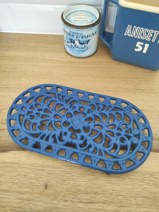 Dessous de plat en fonte émaillé bleu. Ces anciens dessous de plat en fonte émaillée ajourés ont résisté au temps et vu passer un bon nombre de casseroles ! Dessous de plat vintage en très bon état, aucun manque de peinture.