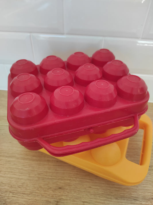 Boîte à œufs vintage rouge années 70. Pour un total look seventies dans votre cuisine ou avant d'aller au marché chercher vos œufs frais, n'oubliez pas la boîte à œufs ! Plus besoin d'emballage ! En plastique rigide rouge made in France. Pour 12 œufs.