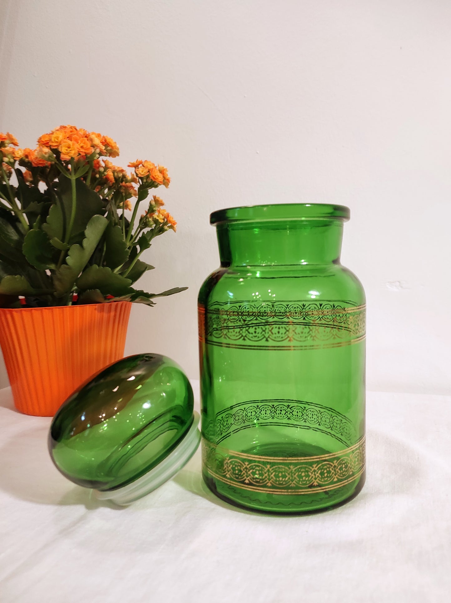 Ce grand bocal en verre vert et son liseré doré vintage de style apothicaire sera parfait pour vos aliments grâce à son bouchon hermétique. En déco, il saura faire son effet en accumulation avec d’autres formats ou d'autres couleurs. Made in Belgium, en très bon état.
