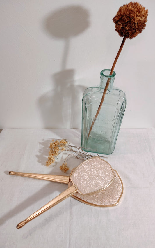 Ancien set à main miroir et brosse à cheveux. On craque pour ce superbe set miroir à main et brosse vintage en métal doré et aux jolies broderies en forme de roses qui apportera touche vintage dans votre salle de bain ou sur une coiffeuse. La base de la brosse est en bois clair. Miroir vintage et brosse à cheveux vintage