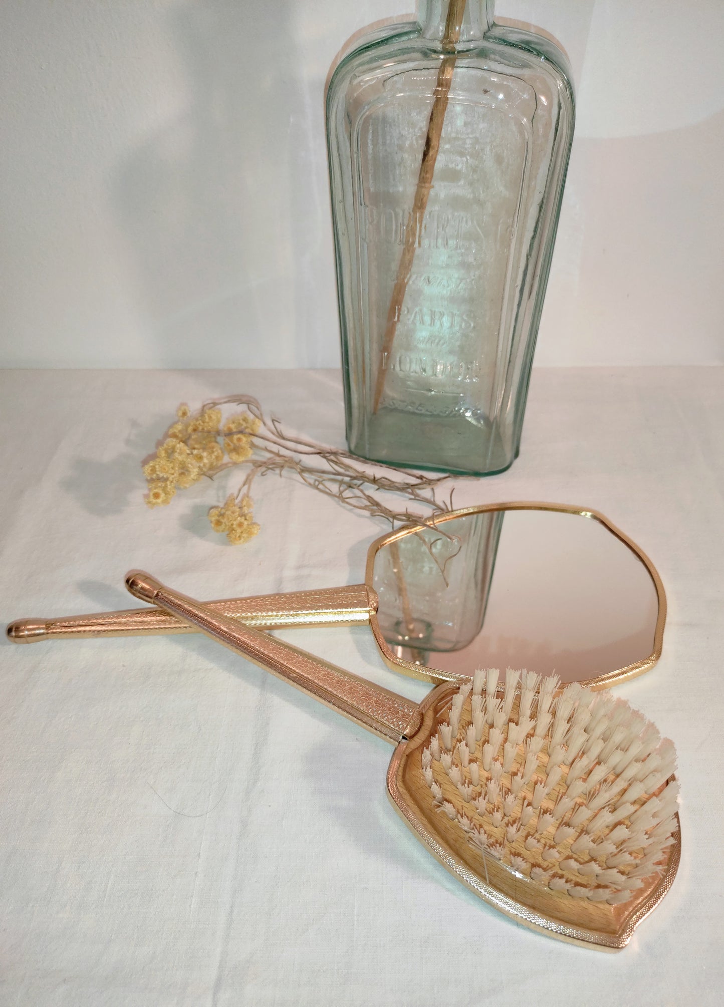 Ancien set à main miroir et brosse à cheveux. On craque pour ce superbe set miroir à main et brosse vintage en métal doré et aux jolies broderies en forme de roses qui apportera touche vintage dans votre salle de bain ou sur une coiffeuse. La base de la brosse est en bois clair. Miroir vintage et brosse à cheveux vintage