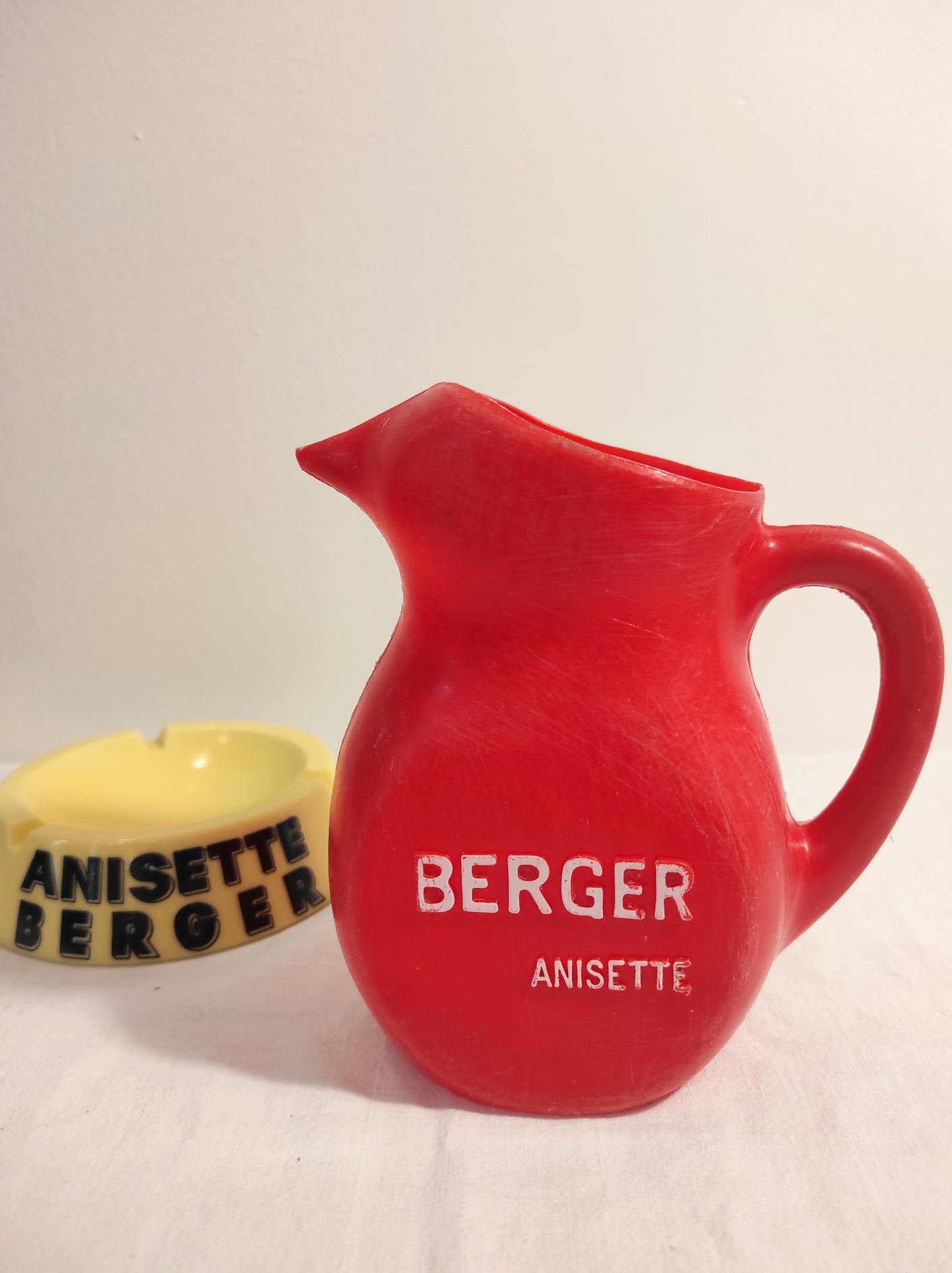 Ancien pichet publicitaire Berger Anisette en plastique rouge. Pour servir votre petite anisette ou simplement en déco, ancien pichet publicitaire Berger Anisette en plastique rouge made in France.