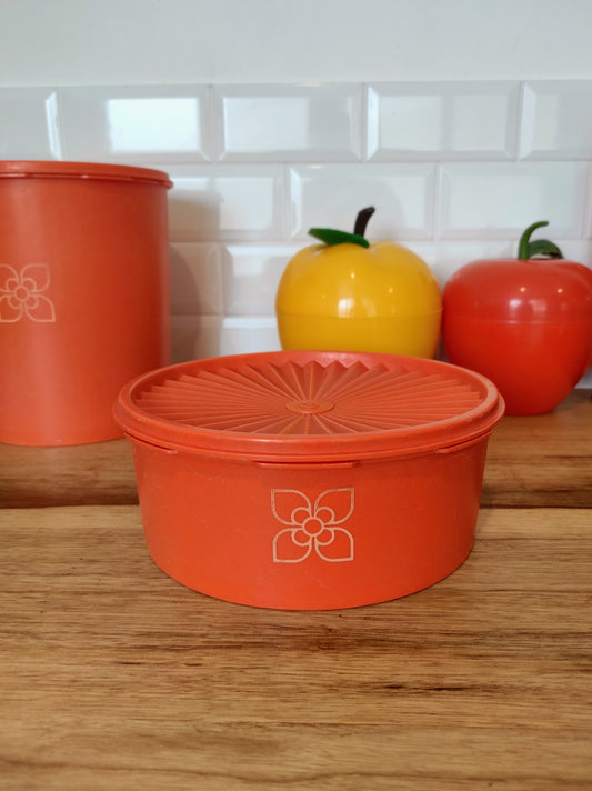 Boite TUPPERWARE soleil orange vintage. Boite TUPPERWARE soleil orange des années 80. Avec son couvercle en forme de soleil, vous n'aurez qu'à appuyer au milieu pour la fermer. En très bon état, made in France.