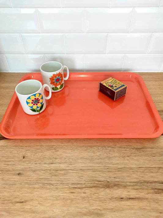 Grand plateau orange vintage. Grand plateau en plastique orange des années 70. On aime sa sobriété et sa belle couleur orange qui donnera une touche de peps dans votre cuisine.