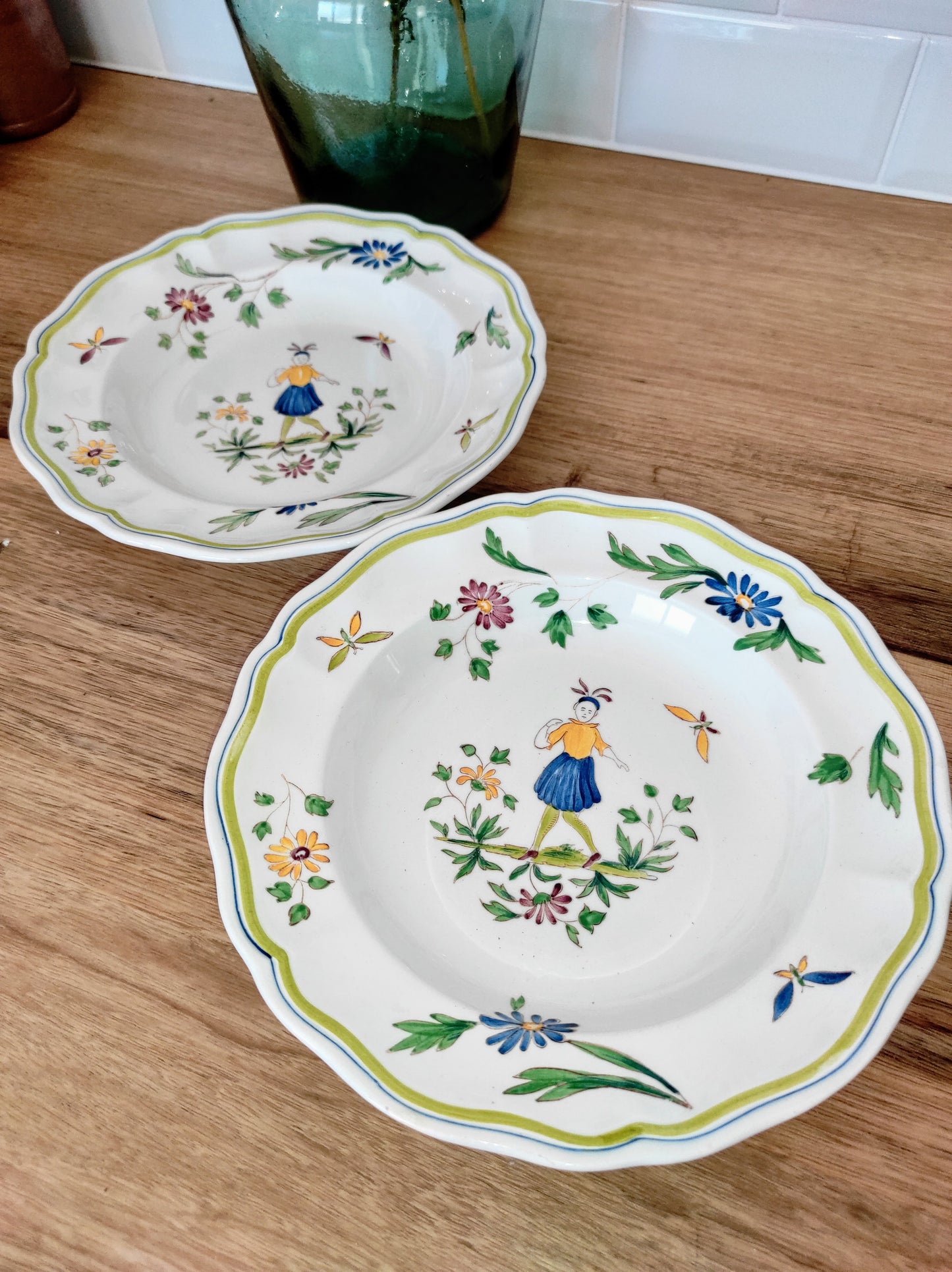 Set de 2 assiettes creuses en faïence de Moustier. Joli set de 2 assiettes creuses en faïence de Moustier dans les tons de verts, jaunes et bleus. Les motifs ont été peints à la main. Made in France , les 2 en très bon état aucun éclat.