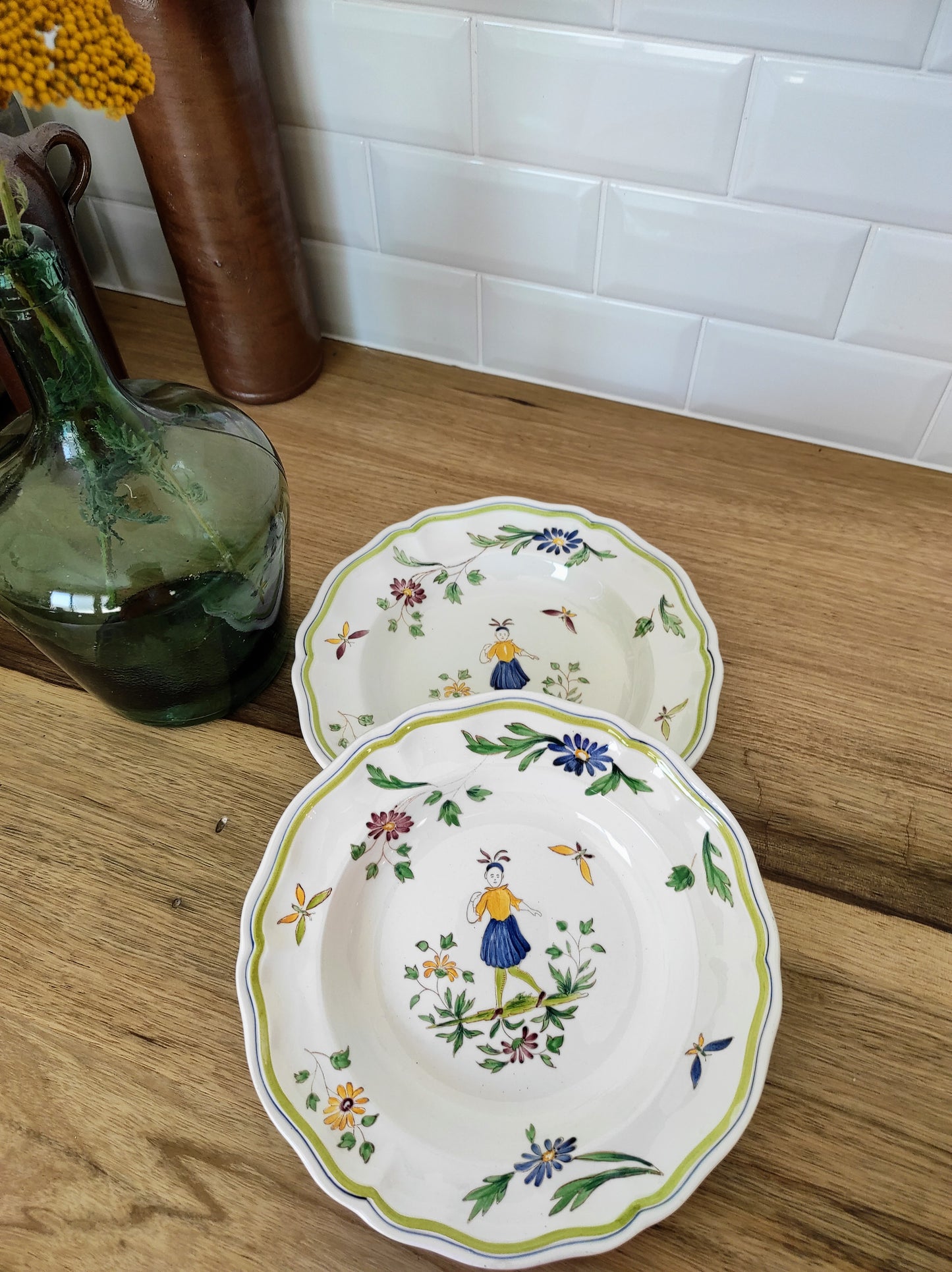 Set de 2 assiettes creuses en faïence de Moustier. Joli set de 2 assiettes creuses en faïence de Moustier dans les tons de verts, jaunes et bleus. Les motifs ont été peints à la main. Made in France , les 2 en très bon état aucun éclat.
