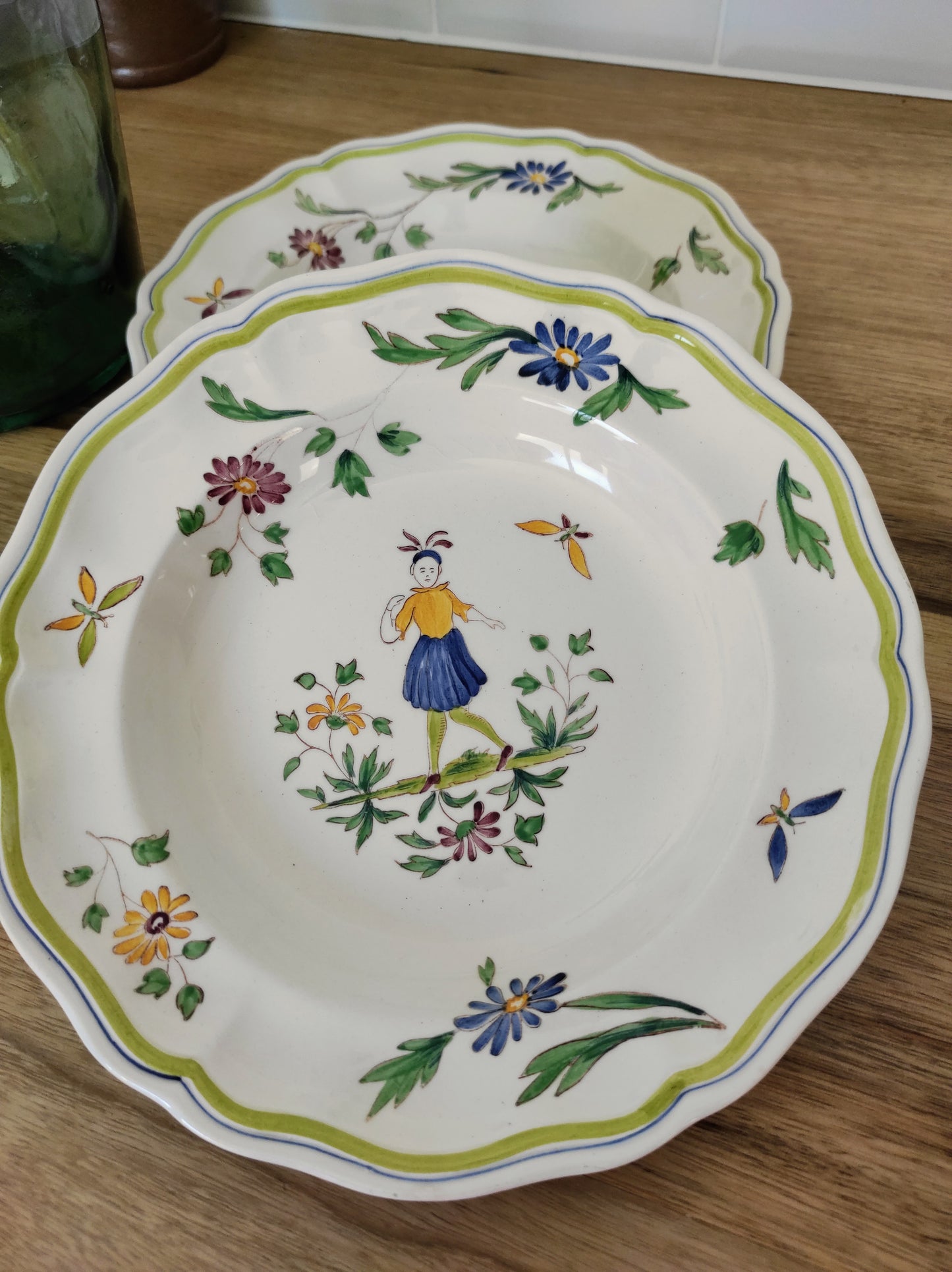 Set de 2 assiettes creuses en faïence de Moustier. Joli set de 2 assiettes creuses en faïence de Moustier dans les tons de verts, jaunes et bleus. Les motifs ont été peints à la main. Made in France , les 2 en très bon état aucun éclat.
