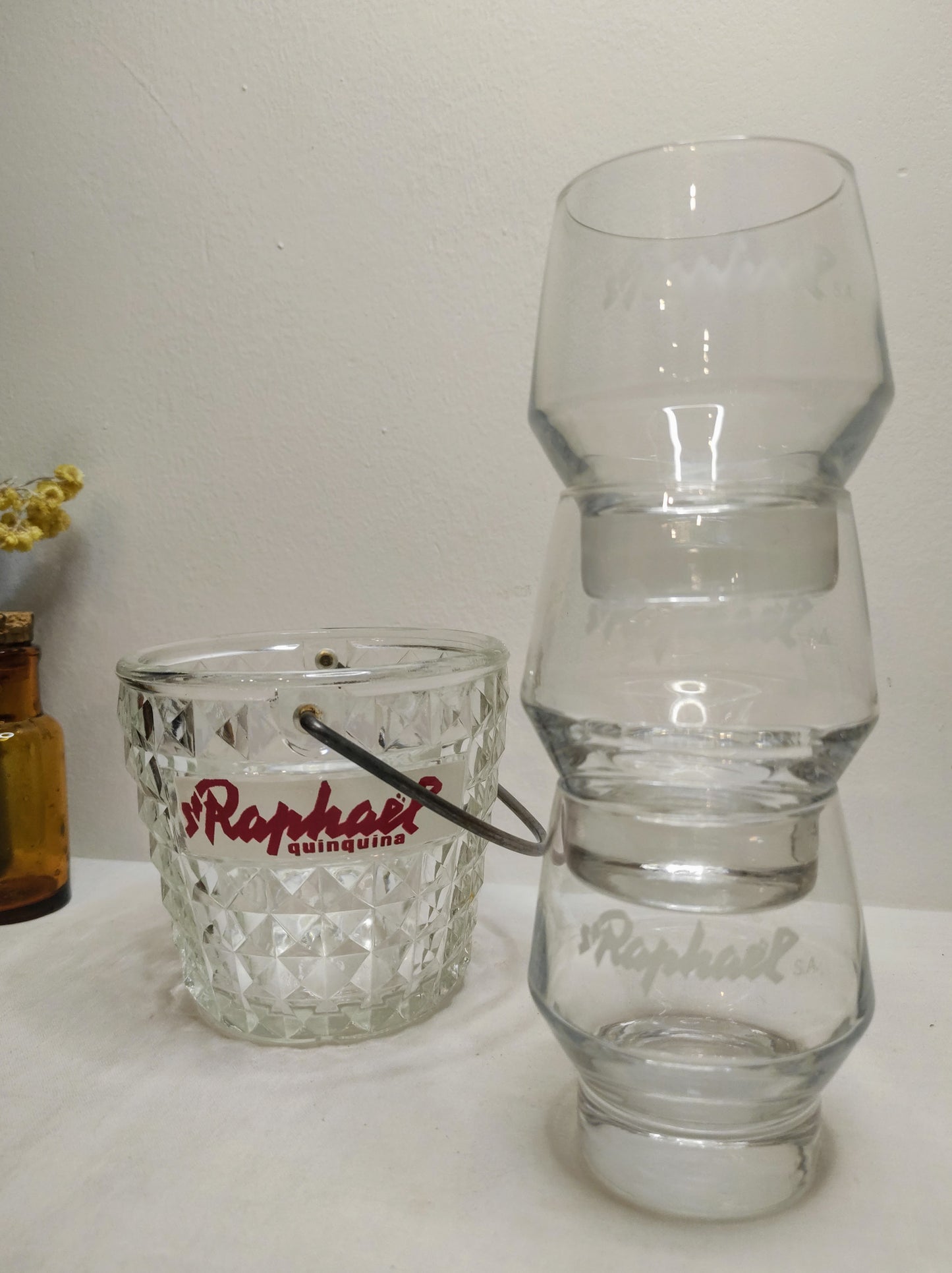 Ancien sceau à glaçons St Raphaël quinquina et ses 3 verres vintage. Pour les fortes chaleurs de l'été n'oubliez pas de rajouter des glaçons dans votre verre ! Ancien sceau à glace en verre moulé St Raphaël quinquina accompagné de 3 verres à liqueur St Raphaël. Made in France, le tout en très bon état.
