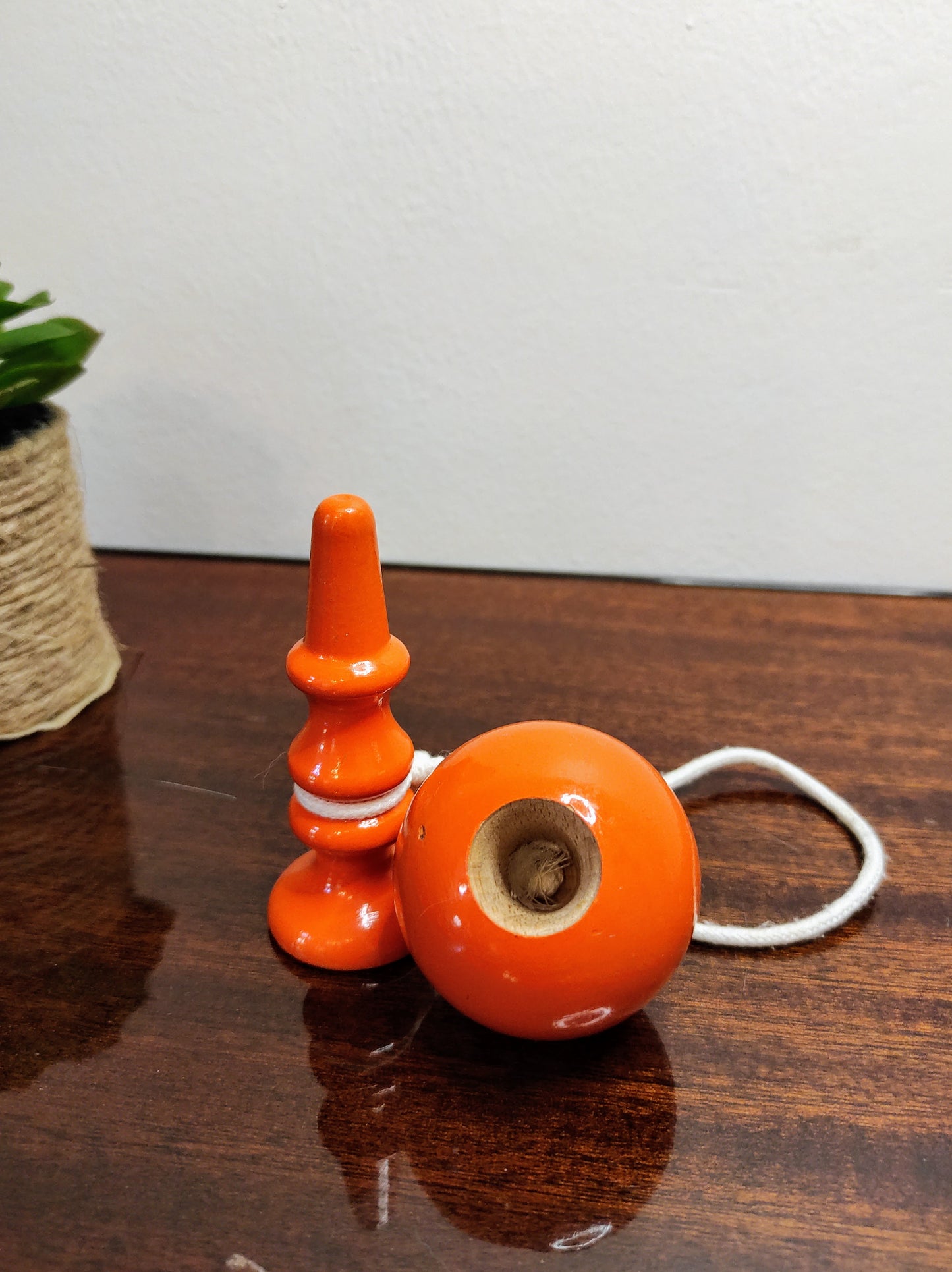 Ancien petit bilboquet en bois orange vintage. Ce joli jouet ancien sera parfait en déco sur une étagère ou dans la chambre de votre bambin ! A noter : en très bon état
