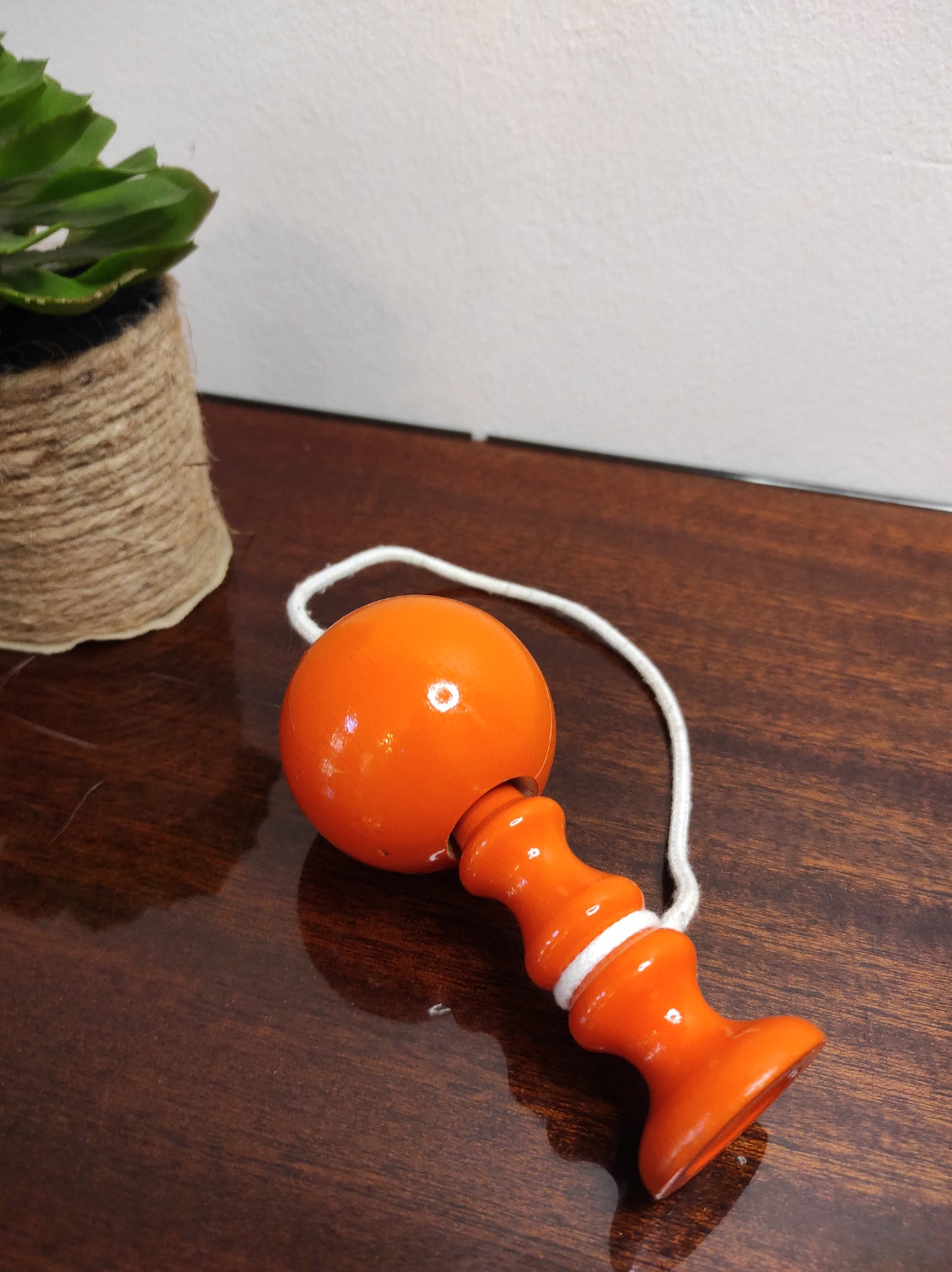 Ancien petit bilboquet en bois orange vintage. Ce joli jouet ancien sera parfait en déco sur une étagère ou dans la chambre de votre bambin ! A noter : en très bon état