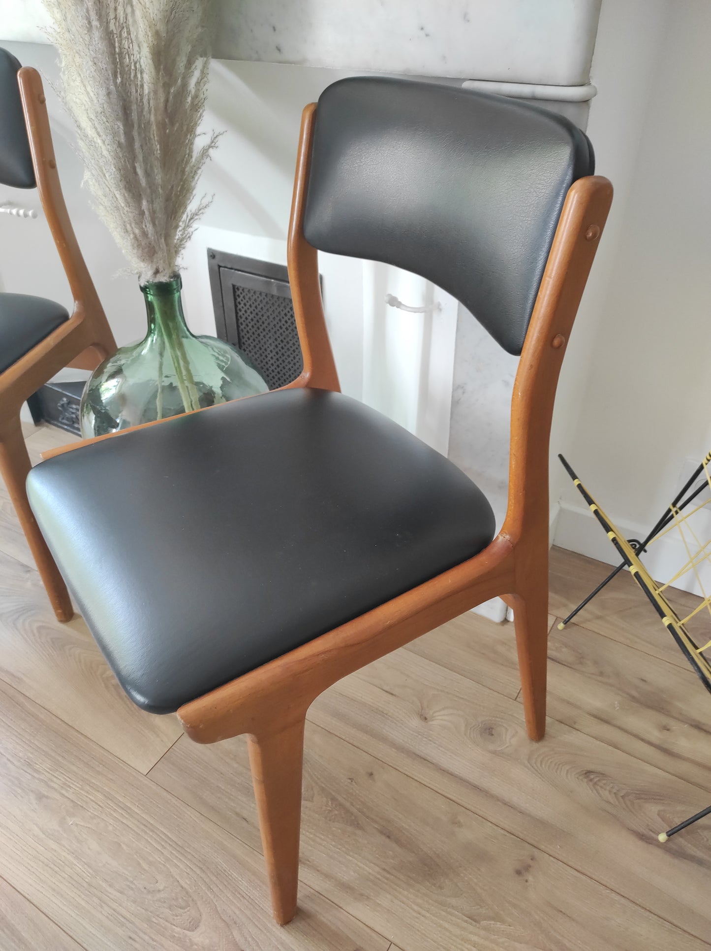 On aime le look sobre de cette jolie paire de chaises scandinaves en bois et skaï noir. Estampillées C.T. 3010, elles sont totalement dans leur jus depuis les années 60. L'assise, le rembourrage et le dessous des chaises sont en très bon état. A noter : un léger accro sur une assise (voir photo) et quelques marques du temps sur le bois notamment au niveau des pieds mais elles restent en très bon état vu leur âge !