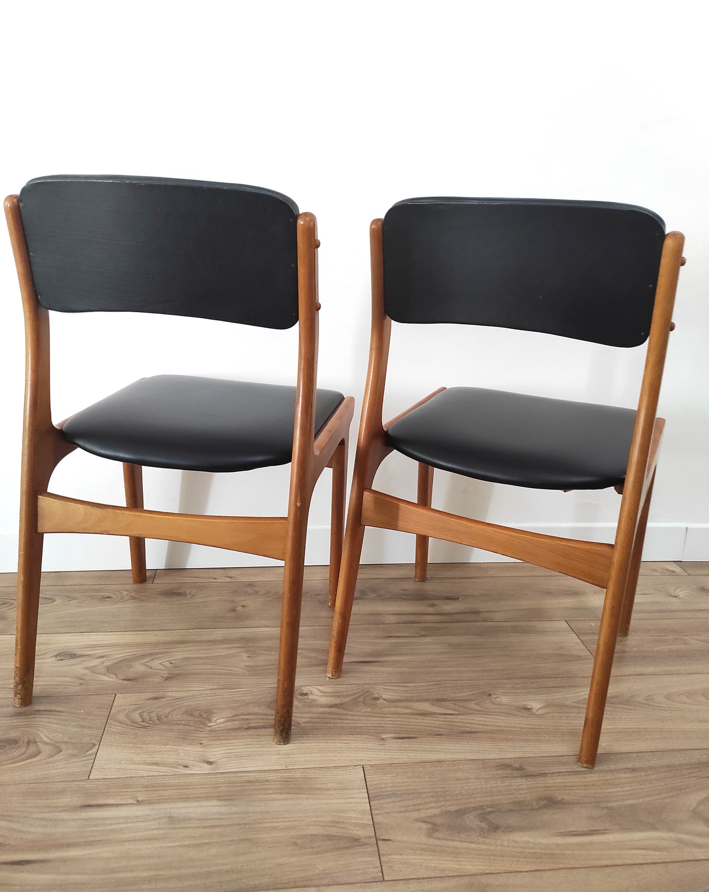 On aime le look sobre de cette jolie paire de chaises scandinaves en bois et skaï noir. Estampillées C.T. 3010, elles sont totalement dans leur jus depuis les années 60. L'assise, le rembourrage et le dessous des chaises sont en très bon état. A noter : un léger accro sur une assise (voir photo) et quelques marques du temps sur le bois notamment au niveau des pieds mais elles restent en très bon état vu leur âge !