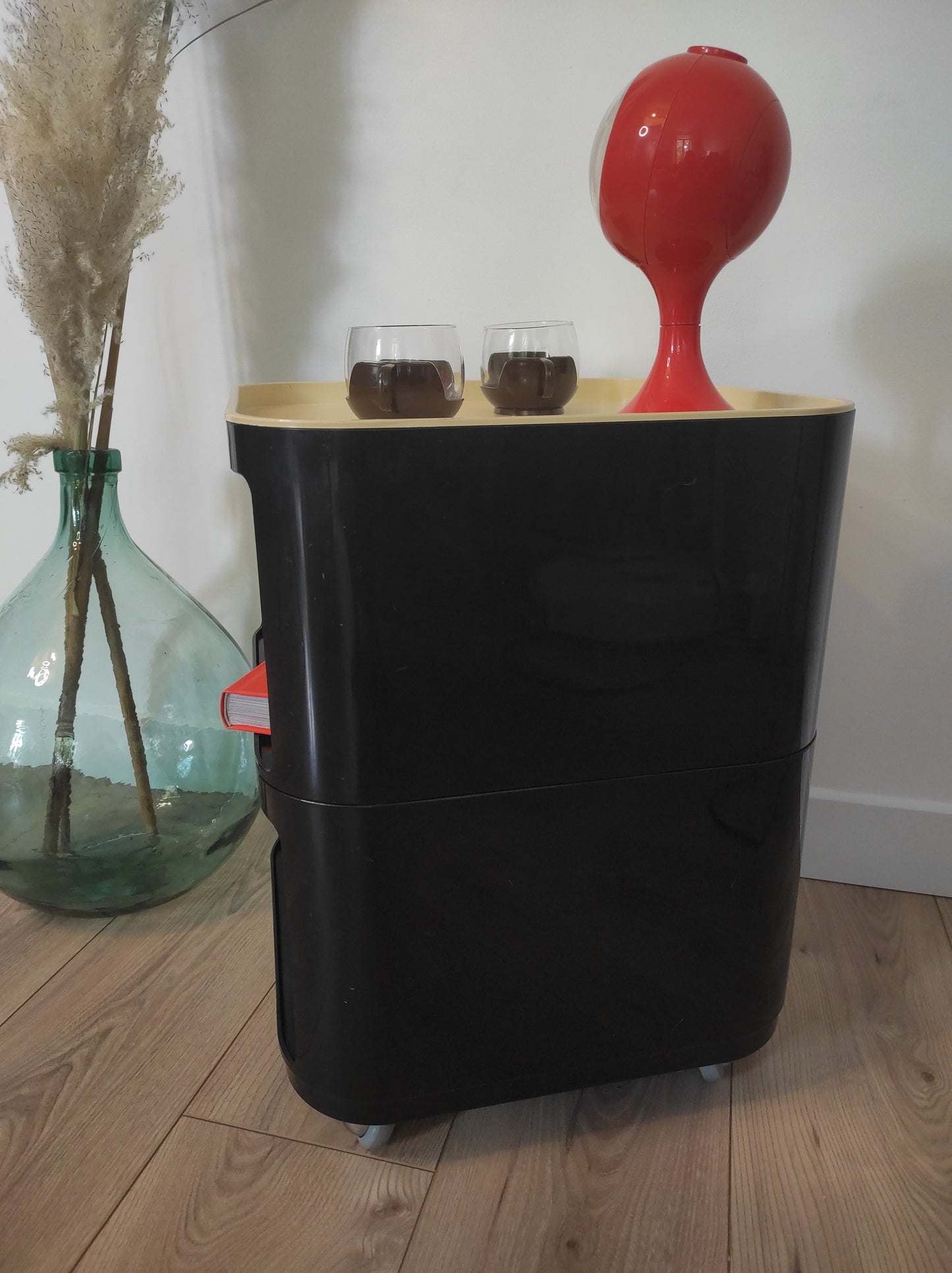 Anna Castelli Ferrieri fait partie de ces grands noms du design qui ont marqué à jamais le mobilier du XXème siècle, notamment avec ce meuble iconique des années 70 sur roulettes, le Componibili Quadrati ! Que dire de plus… si ce n'est que c'est une très belle pièce du design du XXème siècle à avoir chez soi pour tous les amoureux du vintage ! En très bon état, les roulettes fonctionnent très bien, casiers marron et plateau beige.
