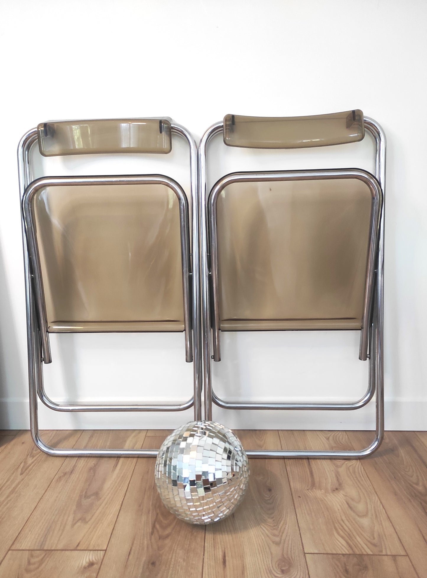 Paire de chaises pliantes vintage plexiglas fumé par Aldo Jacober style PLIA. On aime la simplicité et look très seventies de cette jolie paire de chaises du designer ALDO JACOBER dans le PLIA GIANCARLO PIRETTI CASTELLI. Elles sont totalement dans leur jus depuis les années 70. En plexiglas fumé et métal chromé elle, peu encombrantes, elles seront parfaites dans votre bureau ou autour de votre table ! Les chaises, pour leur âge sont en très bon état malgré quelques traces du temps.