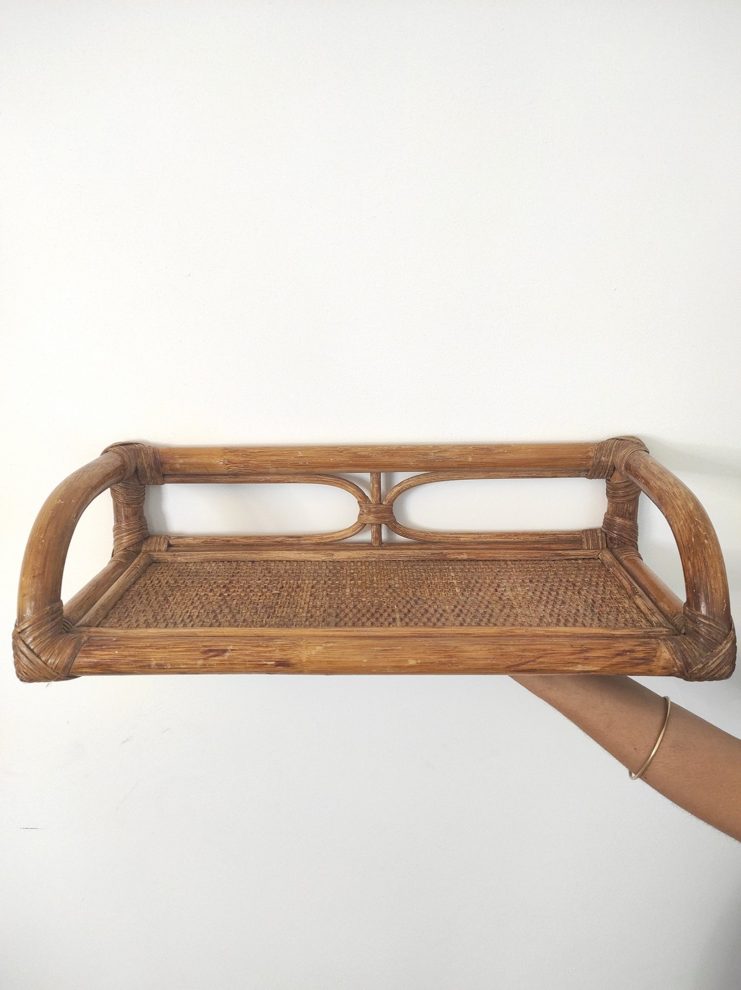 Jolie étagère murale en rotin vintage. Cette ancienne étagère murale en rotin trouvera sa place dans votre intérieur. Son format est idéal pour s'adapter à toutes les pièces de la maison, et accueillir livres ou déco. A noter : Dans son jus, le vernis est un peu passé à certains endroits mais reste en très bon état.