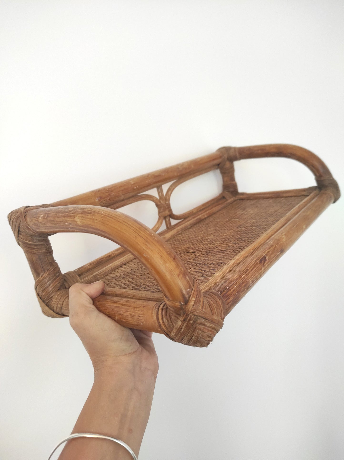 Jolie étagère murale en rotin vintage. Cette ancienne étagère murale en rotin trouvera sa place dans votre intérieur. Son format est idéal pour s'adapter à toutes les pièces de la maison, et accueillir livres ou déco. A noter : Dans son jus, le vernis est un peu passé à certains endroits mais reste en très bon état.