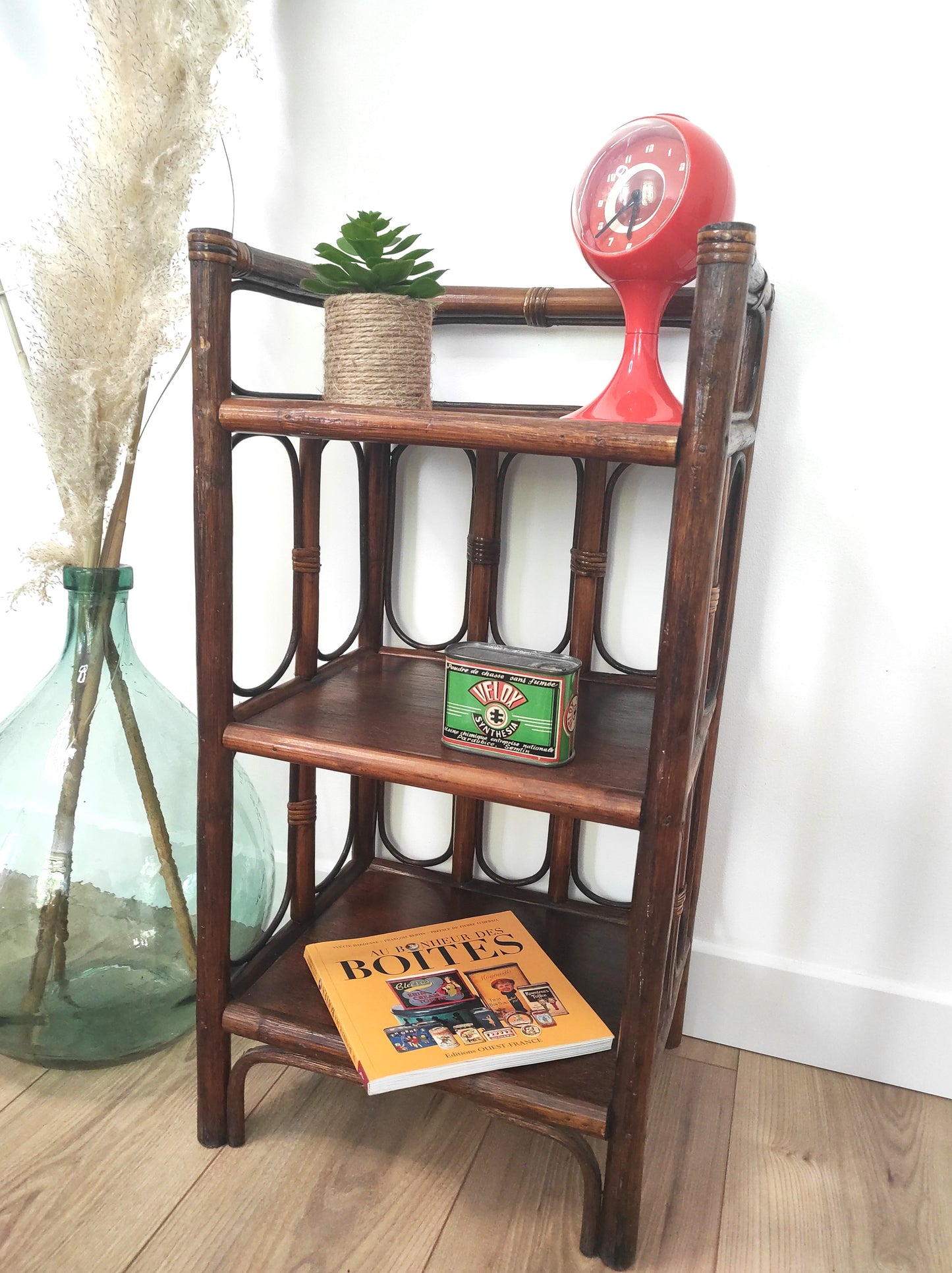 Petite étagère bibliothèque en rotin à poser vintage. Cette jolie petite étagère en rotin à poser vous apportera une ambiance vintage et bohème ! Dans son petit format elle est composée de 3 étagères et apportera une touche d'exotisme dans votre intérieur. Elle trouvera sa place aussi bien dans une chambre, que dans un salon, un bureau ou encore une salle de bain.