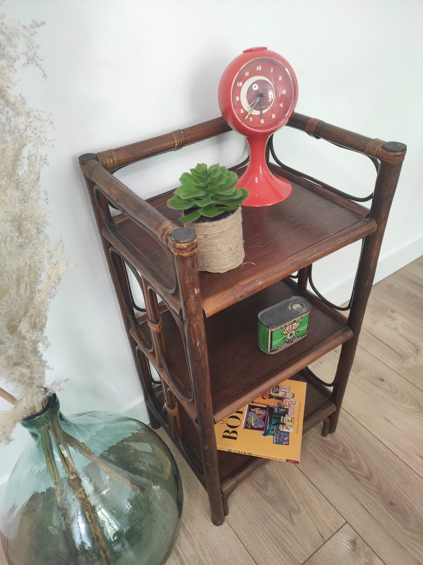Petite étagère bibliothèque en rotin à poser vintage. Cette jolie petite étagère en rotin à poser vous apportera une ambiance vintage et bohème ! Dans son petit format elle est composée de 3 étagères et apportera une touche d'exotisme dans votre intérieur. Elle trouvera sa place aussi bien dans une chambre, que dans un salon, un bureau ou encore une salle de bain.