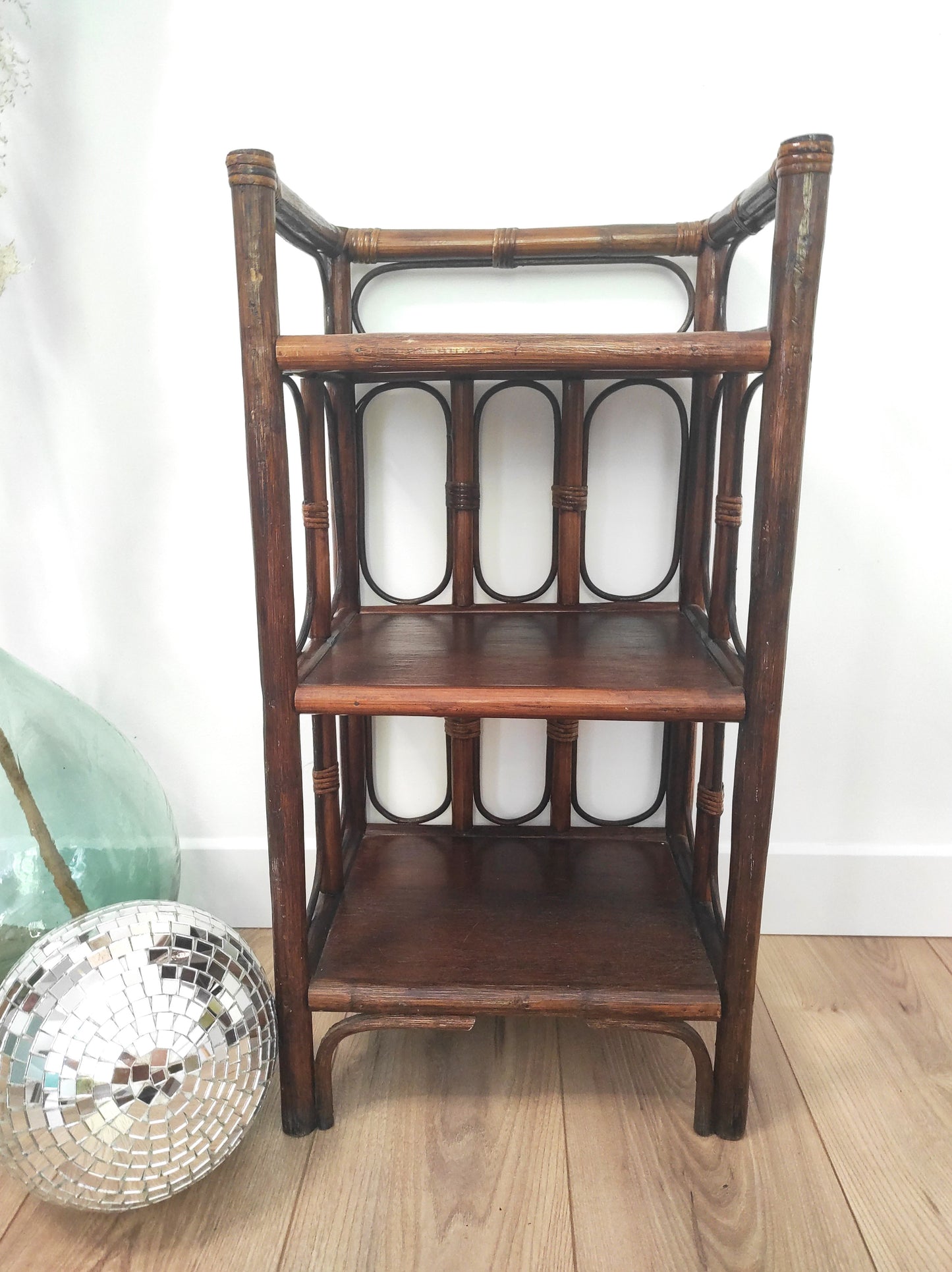 Petite étagère bibliothèque en rotin à poser vintage. Cette jolie petite étagère en rotin à poser vous apportera une ambiance vintage et bohème ! Dans son petit format elle est composée de 3 étagères et apportera une touche d'exotisme dans votre intérieur. Elle trouvera sa place aussi bien dans une chambre, que dans un salon, un bureau ou encore une salle de bain.