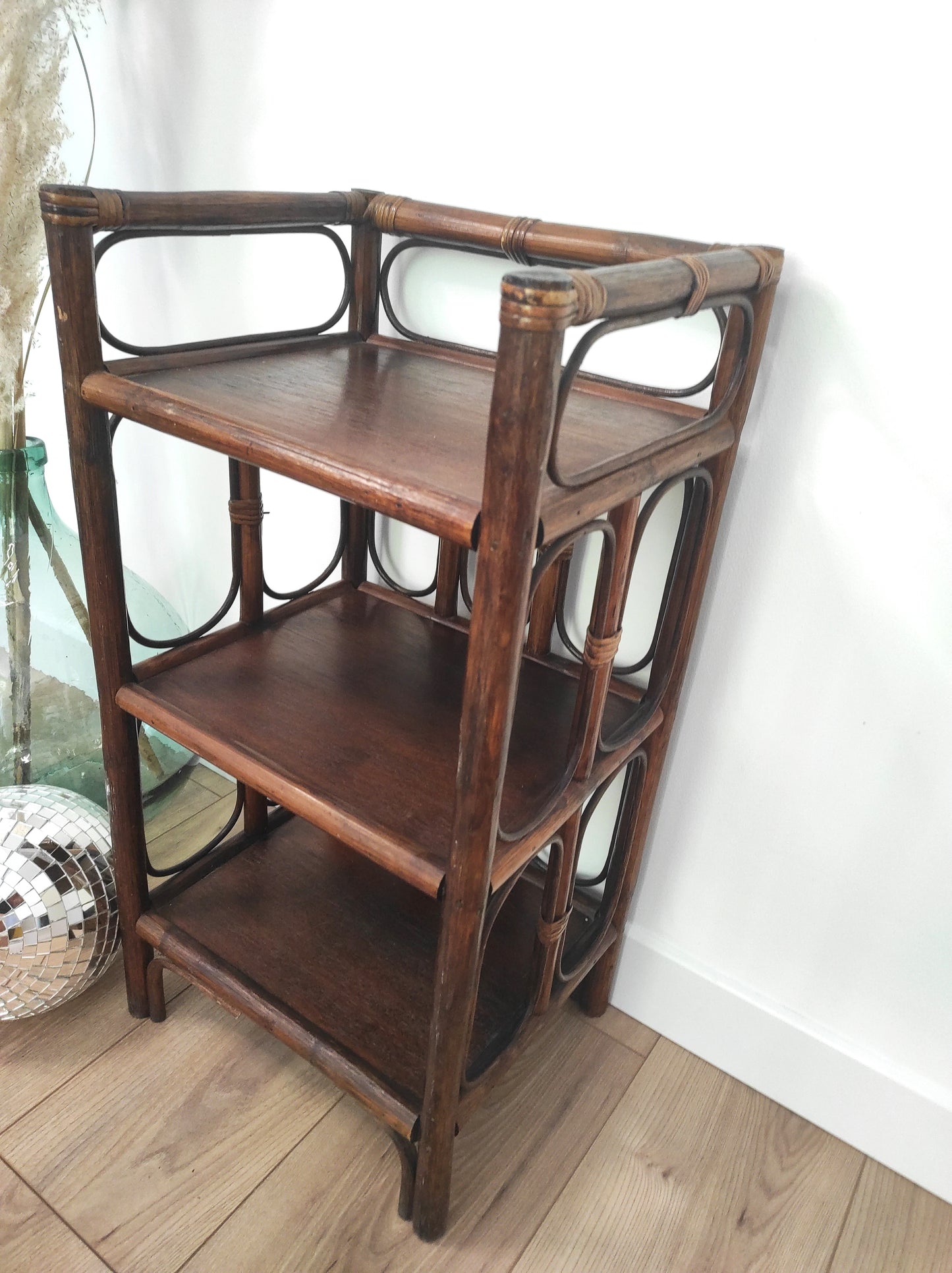 Petite étagère bibliothèque en rotin à poser vintage. Cette jolie petite étagère en rotin à poser vous apportera une ambiance vintage et bohème ! Dans son petit format elle est composée de 3 étagères et apportera une touche d'exotisme dans votre intérieur. Elle trouvera sa place aussi bien dans une chambre, que dans un salon, un bureau ou encore une salle de bain.