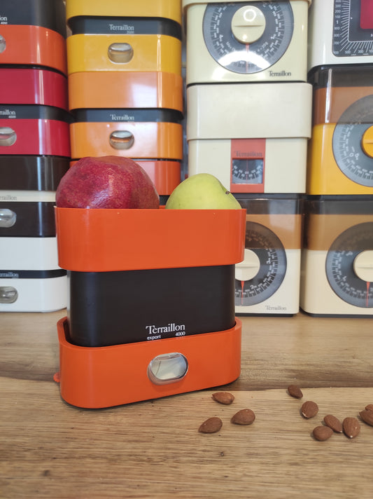 Copie de Balance de cuisine vintage Terraillon Export 4000 orange. Qui ne la connait pas ? La balance mécanique Terraillon est un modèle incontournable de l’électroménager vintage à avoir ! En parfait état de fonctionnement elle sera très jolie aussi en déco dans votre cuisine. Pesée possible jusqu’à 4kg, graduée par 20gr, une petite molette de tare sur le coté. Dans son jus avec quelques traces du passé mais fonctionne parfaitement. Balance de cuisine vintage