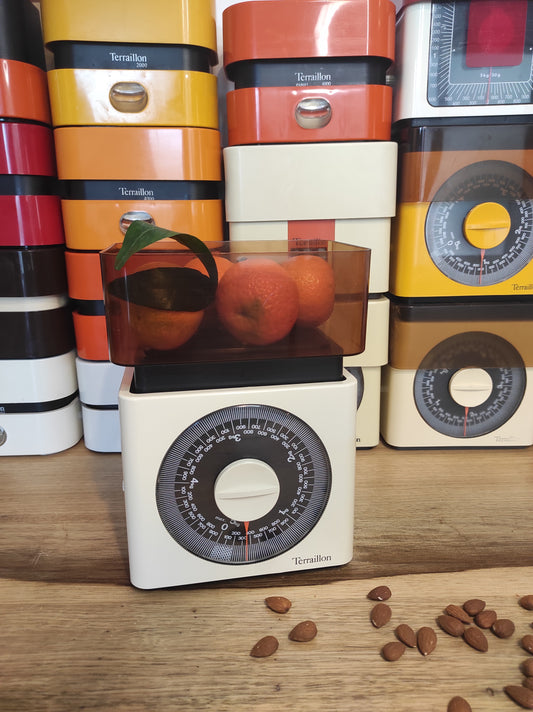 Balance de cuisine Terraillon vintage blanche (jusqu'à 5 kg). Qui ne la connait pas ? La balance mécanique Terraillon est un modèle incontournable de l’électroménager vintage à avoir ! En parfait état de fonctionnement elle sera très jolie aussi en déco dans votre cuisine. Pesée de 20 gr à 5 kg Dans son jus avec quelques traces du passé mais fonctionne parfaitement.