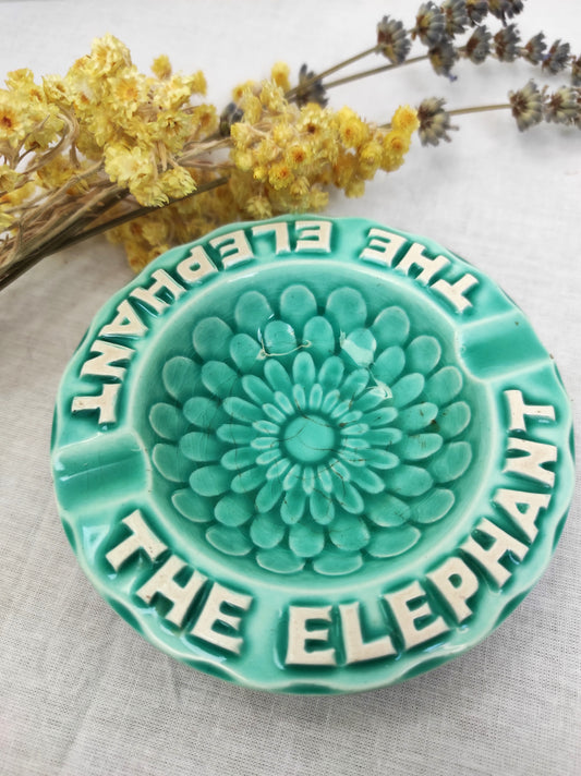 Ancien petit cendrier publicitaire Thé Éléphant . Joli petit cendrier publicitaire vintage pour la marque "Thé Elephant" en faïence de couleur bleu céladon. Le fond à des motifs en forme de pétales. Il fera une superbe déco rétro et colorée sur une étagère ou un joli vide poche sur une commode !