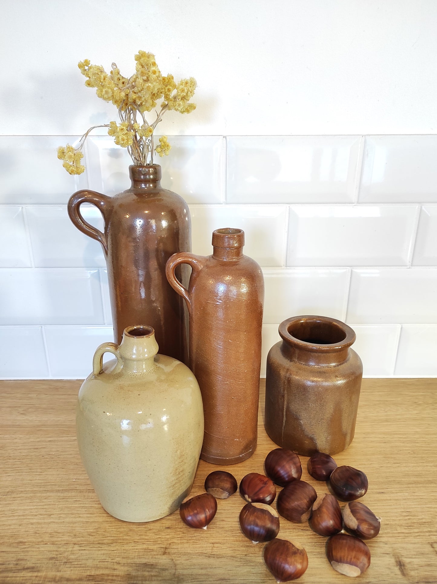 Ancienne bouteille en grès vernissé 23 cm. Jolie bouteille ancienne en grès vernissé avec anse. Un peu plus petite que sa grande sœur elle reste tout de même très décorative et accueillera à merveille vos fleurs séchées. En déco, elle fera aussi faire son effet en accumulation avec d’autres formats ou d'autres couleurs. Bouteille vintage