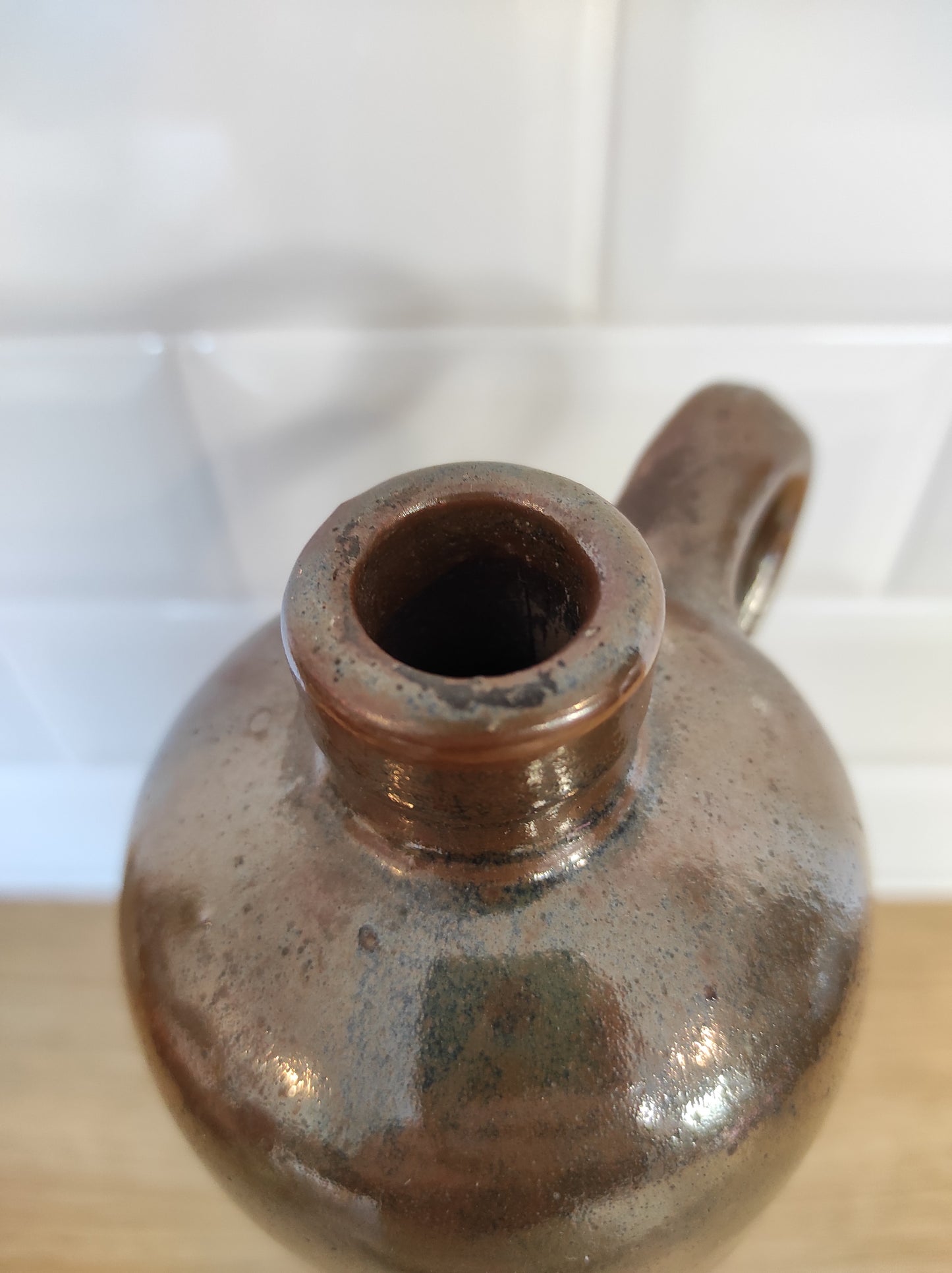 Ancienne bouteille en grès vernissé. Jolie bouteille ancienne en grès vernissé avec anse. Sa forme élancée est très décorative et accueillera à merveille vos fleurs séchées. En déco, elle fera aussi faire son effet en accumulation avec d’autres formats ou d'autres couleurs. A noter : la bouteille ayant était faite artisanalement, elle porte quelques petits défauts qui n'enlèvent rien à son charme. Aucun éclat.