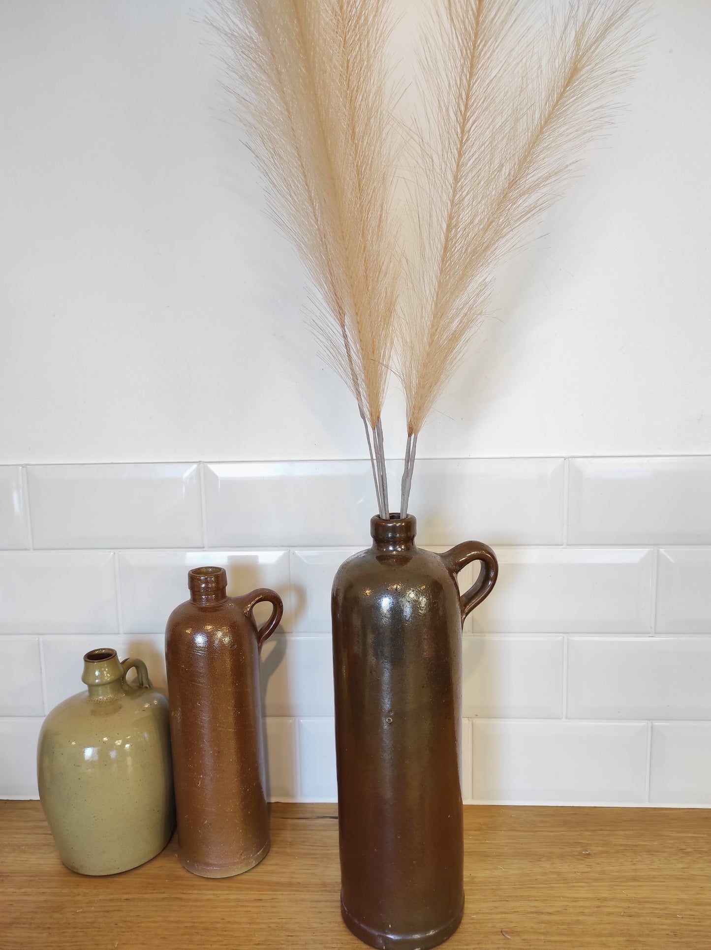 Ancienne bouteille en grès vernissé. Jolie bouteille ancienne en grès vernissé avec anse. Sa forme élancée est très décorative et accueillera à merveille vos fleurs séchées. En déco, elle fera aussi faire son effet en accumulation avec d’autres formats ou d'autres couleurs. A noter : la bouteille ayant était faite artisanalement, elle porte quelques petits défauts qui n'enlèvent rien à son charme. Aucun éclat.