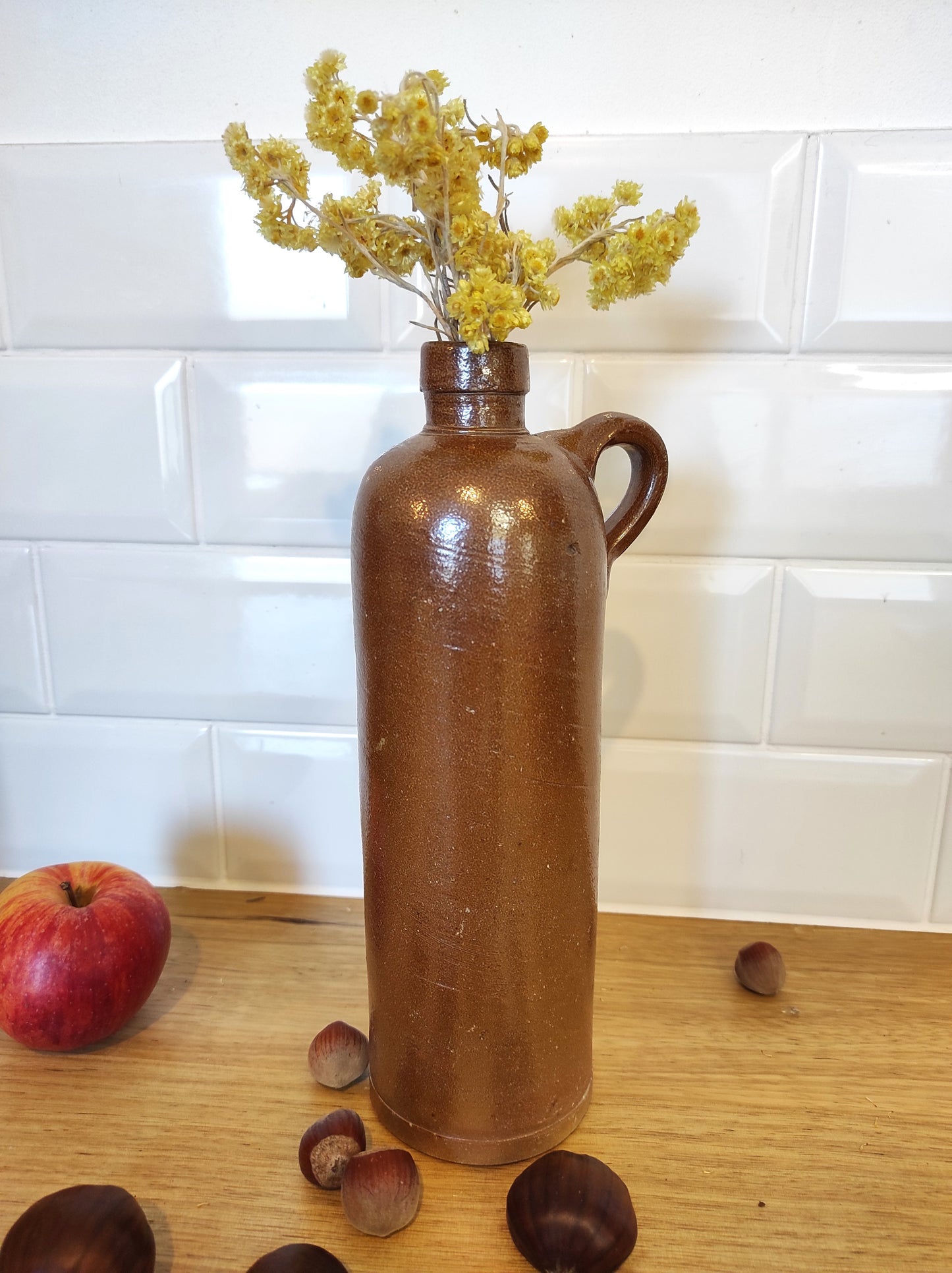 Ancienne bouteille en grès vernissé 23 cm. Bouteille vintage. Jolie bouteille ancienne en grès vernissé avec anse. Un peu plus petite que sa grande sœur elle reste tout de même très décorative et accueillera à merveille vos fleurs séchées. En déco, elle fera aussi faire son effet en accumulation avec d’autres formats ou d'autres couleurs.