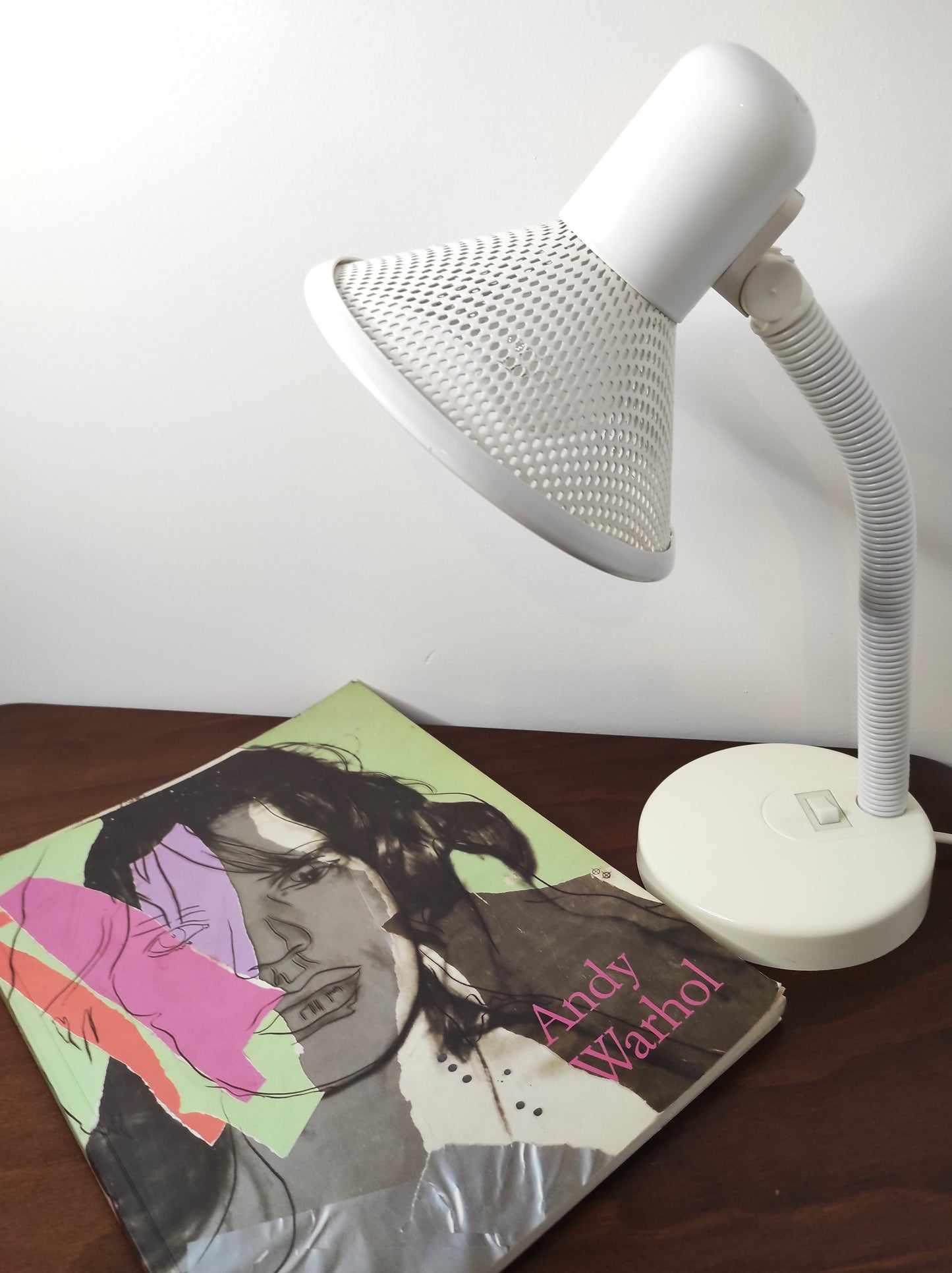 Lampe de bureau blanche des années 80. Ancienne lampe de bureau, lampe à poser en aluminium blanc des années 80 son abat-jour ajouré est orientable (haut/bas) et son interrupteur est sur le pied. Electrification d'origine vérifiée, en bon état, ampoule vis.