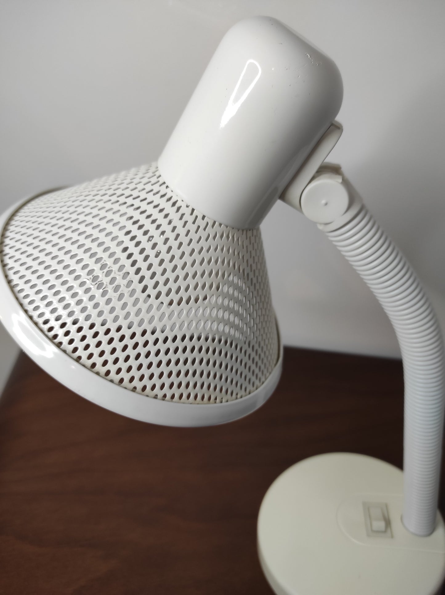 Lampe de bureau blanche des années 80. Ancienne lampe de bureau, lampe à poser en aluminium blanc des années 80 son abat-jour ajouré est orientable (haut/bas) et son interrupteur est sur le pied. Electrification d'origine vérifiée, en bon état, ampoule vis.