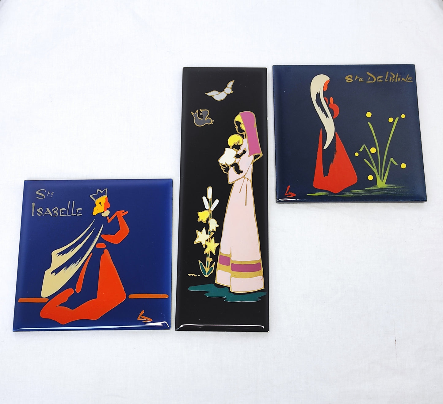 Ancien carreau en céramique religieux peint à la main. Cet ancien carreau religieux en céramique de couleur noir peint à la main représentant la vierge à l'enfant trouvera sa place dans votre intérieur à coup sûr ! Au dos de ce carreau vous trouverez une feutrine bleu ciel et une attache en laiton. En bon état général, très légers petits éclats sur la tranche (voir photo). Décoration murale vintage.