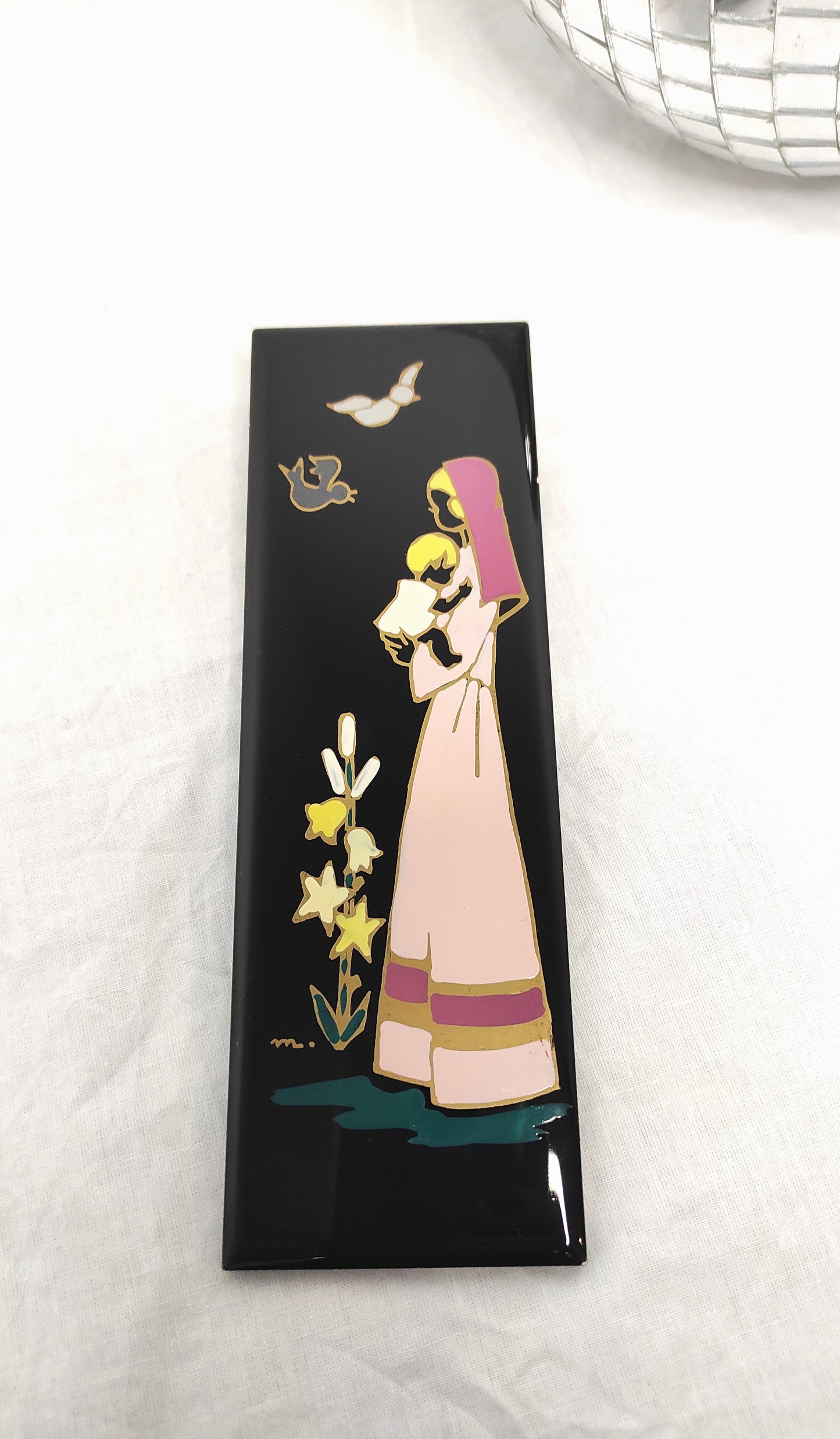 Ancien carreau en céramique religieux peint à la main. Cet ancien carreau religieux en céramique de couleur noir peint à la main représentant la vierge à l'enfant trouvera sa place dans votre intérieur à coup sûr ! Au dos de ce carreau vous trouverez une feutrine bleu ciel et une attache en laiton. En bon état général, très légers petits éclats sur la tranche (voir photo). Décoration murale vintage.