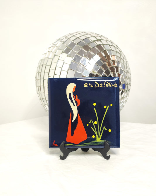 Ancien carreau en céramique religieux peint à la main. Cet ancien carreau religieux en céramique e couleur bleu nuit peint à la main représentant Ste Delphine trouvera sa place dans votre intérieur....ou dans celui d'une Delphine ! Au dos de ce carreau vous trouverez la petite histoire de Ste Delphine sur une feutrine bleu turquoise. En bon état général, léger petit éclat dans coin haut gauche mais ne se voit pas une fois au mur (voir photo) . Attache à l'arrière. Décoration murale vintage.