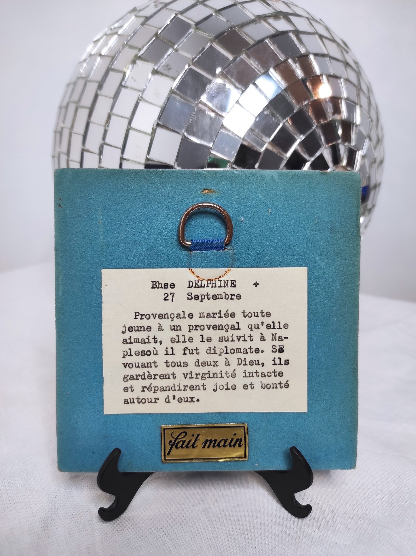 Ancien carreau en céramique religieux peint à la main. Cet ancien carreau religieux en céramique e couleur bleu nuit peint à la main représentant Ste Delphine trouvera sa place dans votre intérieur....ou dans celui d'une Delphine ! Au dos de ce carreau vous trouverez la petite histoire de Ste Delphine sur une feutrine bleu turquoise. En bon état général, léger petit éclat dans coin haut gauche mais ne se voit pas une fois au mur (voir photo) . Attache à l'arrière. Décoration murale vintage.