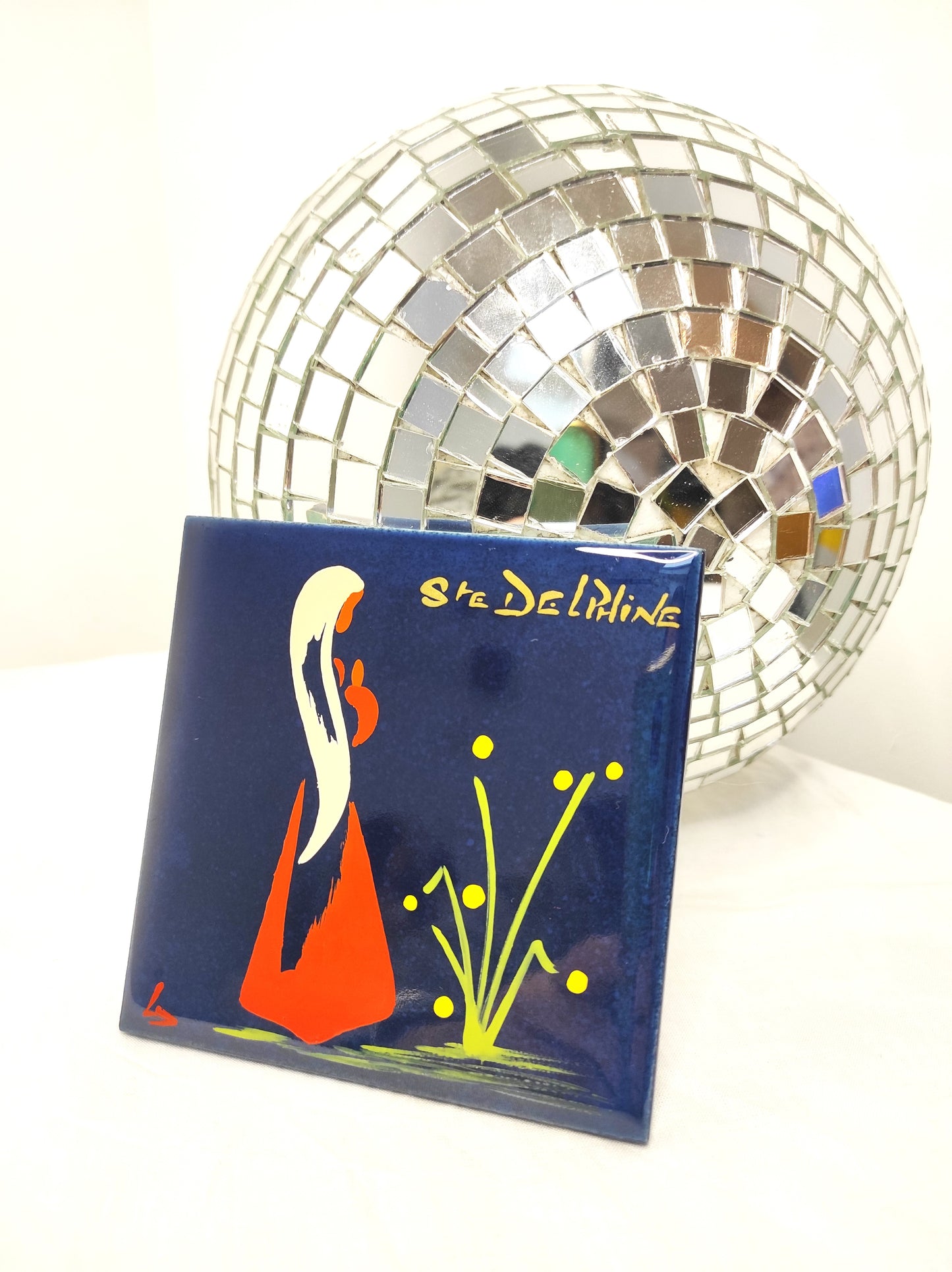 Ancien carreau en céramique religieux peint à la main. Cet ancien carreau religieux en céramique e couleur bleu nuit peint à la main représentant Ste Delphine trouvera sa place dans votre intérieur....ou dans celui d'une Delphine ! Au dos de ce carreau vous trouverez la petite histoire de Ste Delphine sur une feutrine bleu turquoise. En bon état général, léger petit éclat dans coin haut gauche mais ne se voit pas une fois au mur (voir photo) . Attache à l'arrière. Décoration murale vintage.