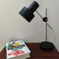Lampe de bureau vintage noire style Jan Suchan. Cette jolie lampe en métal noire aux formes épurées trouvera facilement sa place sur votre bureau ou en décoration dans votre intérieur !  Lampe de bureau, lampe à poser des années 60 est flexible et orientable grâce à son pied en aluminium.   Electrification d'origine vérifiée, en bon état, douille à baïonnette.