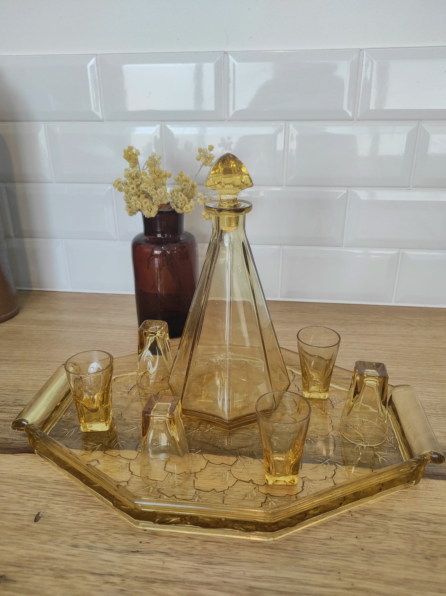 Ancien service à liqueur art déco en verre jaune comprenant 6 verres, une carafe et un plateau assez lourd aux motifs feuilles de vigne.  Le service est en très bon état. 