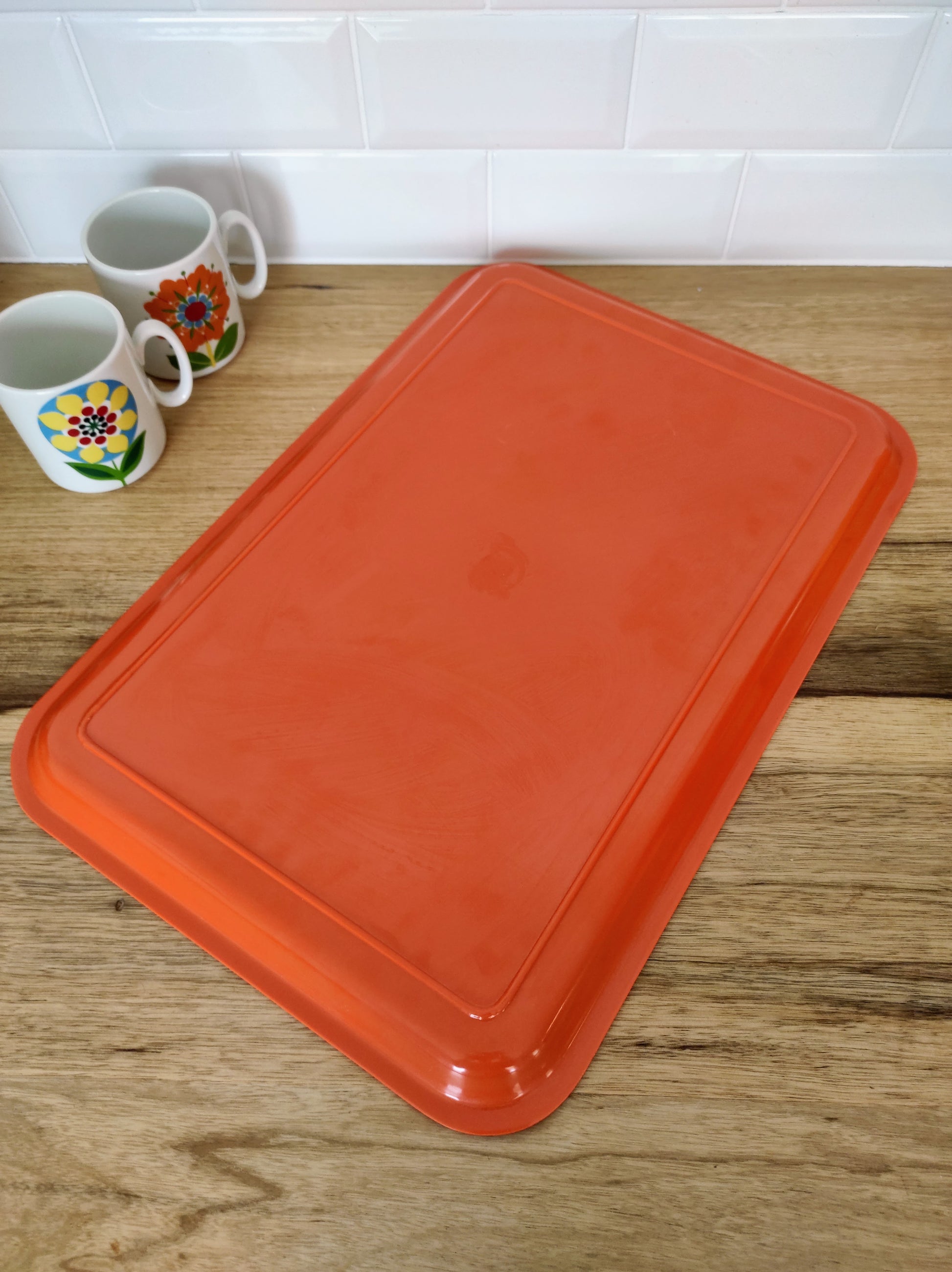 Grand plateau orange vintage. Grand plateau en plastique orange des années 70.  On aime sa sobriété et sa belle couleur orange qui donnera une touche de peps dans votre cuisine. 