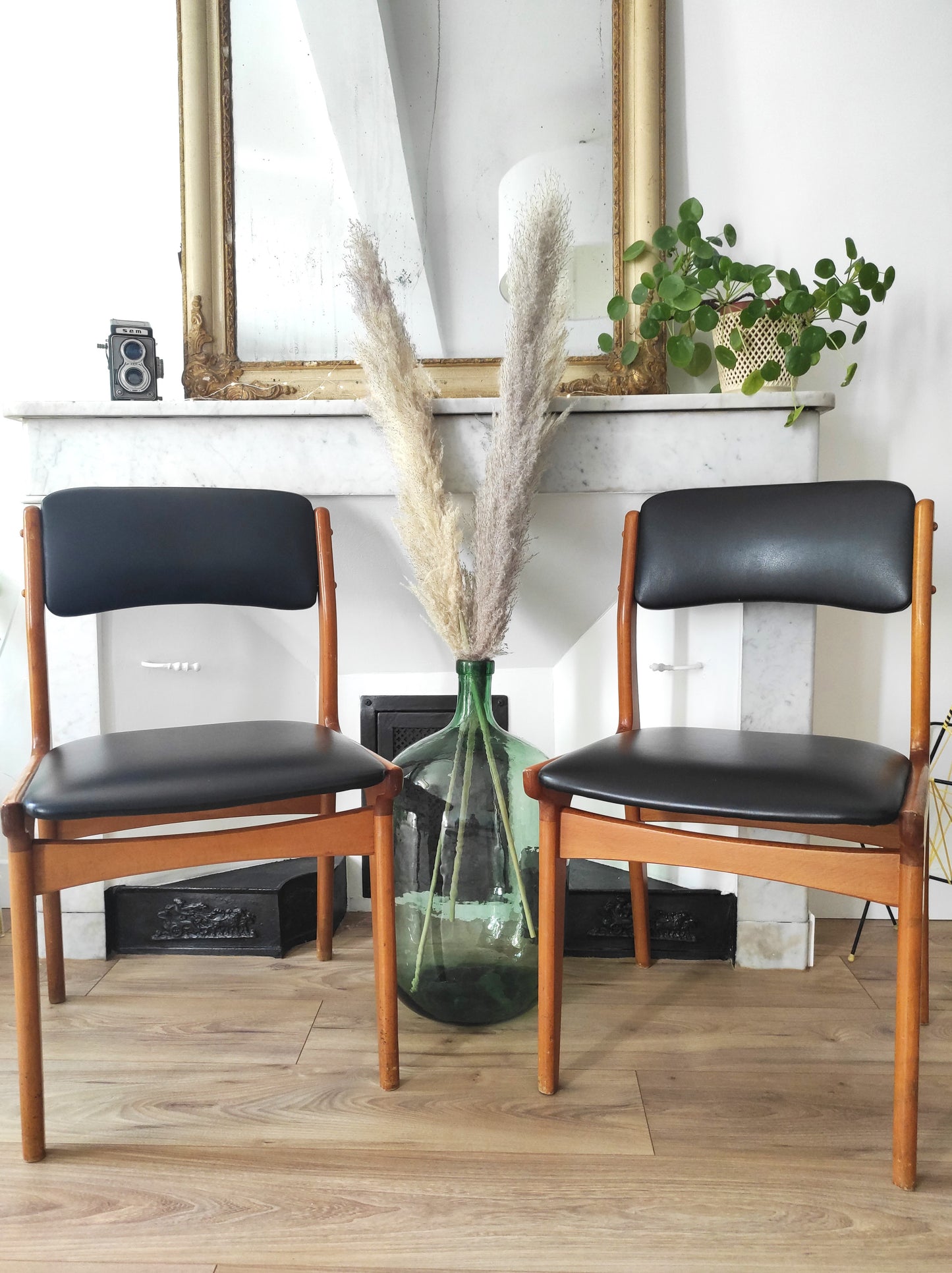 On aime le look sobre de cette jolie paire de chaises scandinaves en bois et skaï noir.   Estampillées C.T. 3010, elles sont totalement dans leur jus depuis les années 60.   L'assise, le rembourrage et le dessous des chaises sont en très bon état.   A noter : un léger accro sur une assise (voir photo) et quelques marques du temps sur le bois notamment au niveau des pieds mais elles restent en très bon état vu leur âge !