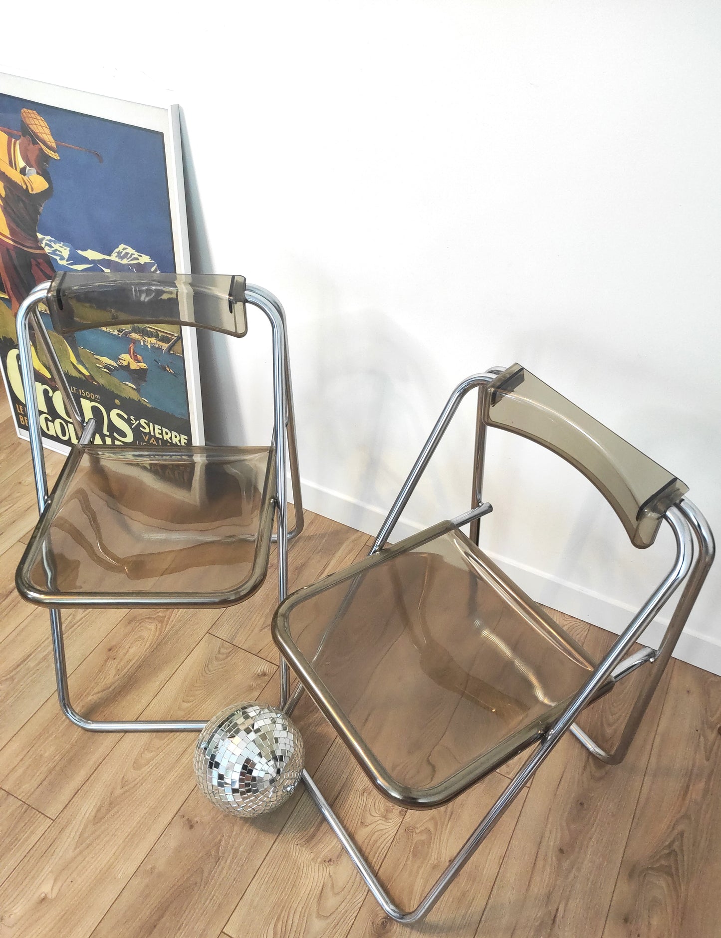 Paire de chaises pliantes vintage plexiglas fumé par Aldo Jacober style PLIA. On aime la simplicité et look très seventies de cette jolie paire de chaises du designer ALDO JACOBER dans le style PLIA GIANCARLO PIRETTI CASTELLI.  Elles sont totalement dans leur jus depuis les années 70.   En plexiglas fumé et métal chromé , peu encombrantes, elles seront parfaites dans votre bureau ou autour de votre table !   Les chaises, pour leur âge sont en très bon état malgré quelques traces du temps.